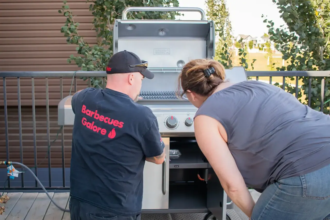 A Barbecues Galore expert walking a customer through a new grill