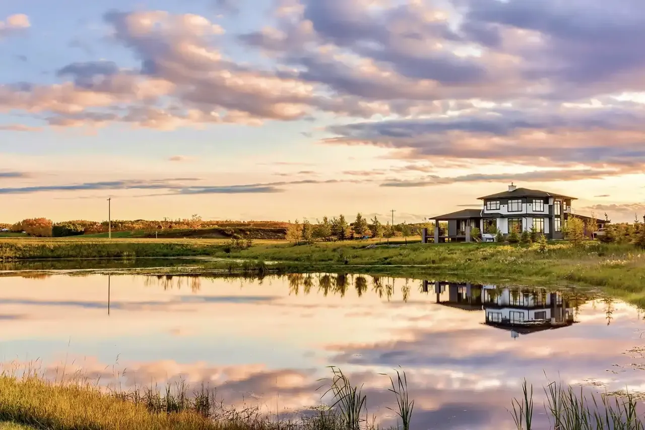 A Silverpeak Estates home reflected in a pond at sunset