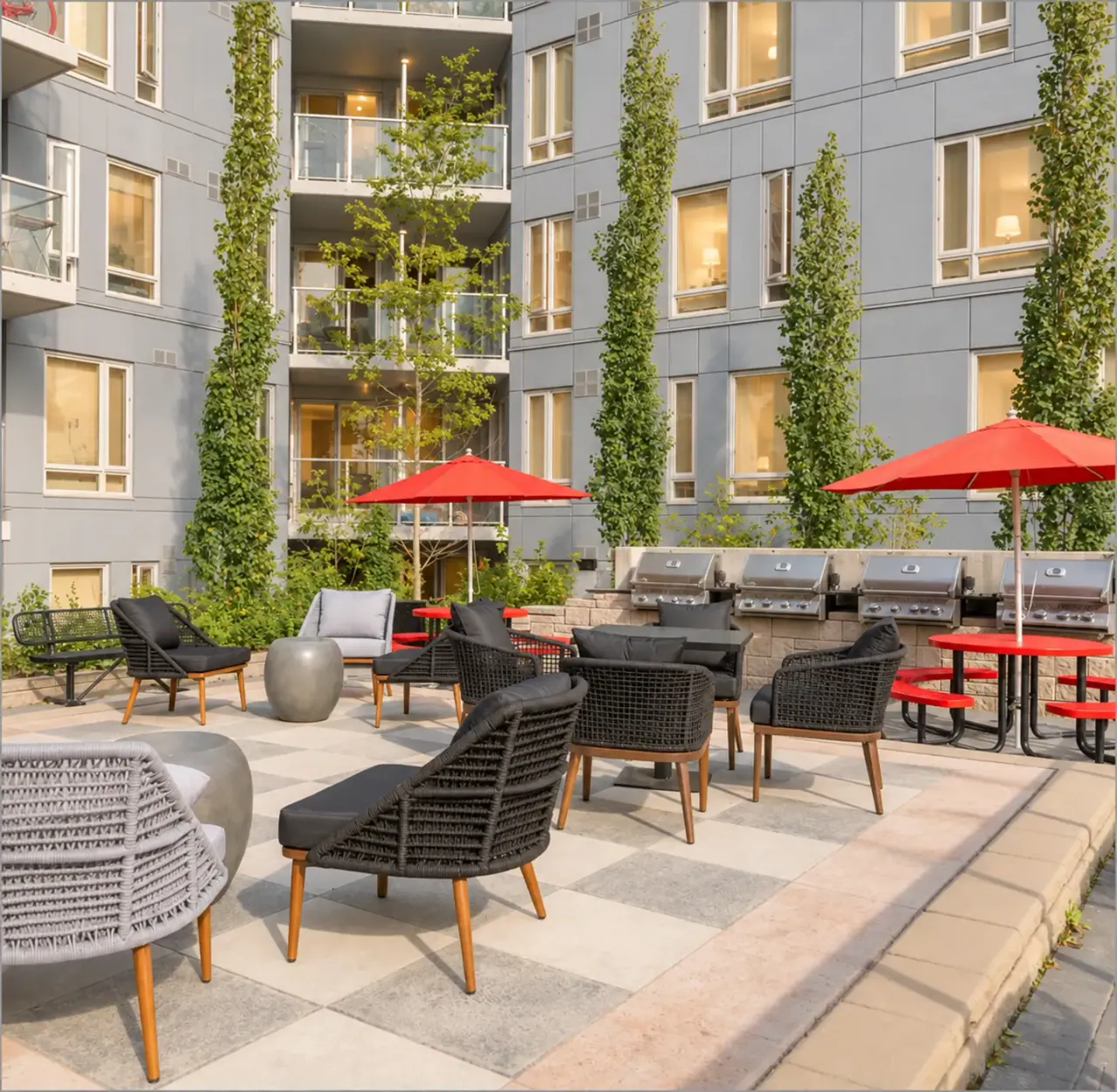 The Metropole's landscaped courtyard with lounge chairs, barbecues and red umbrellas