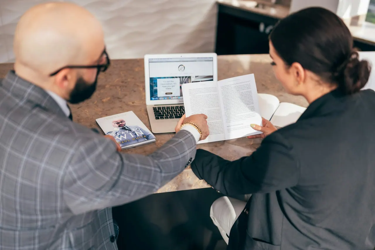 An accountant and a client going through a document together at a table