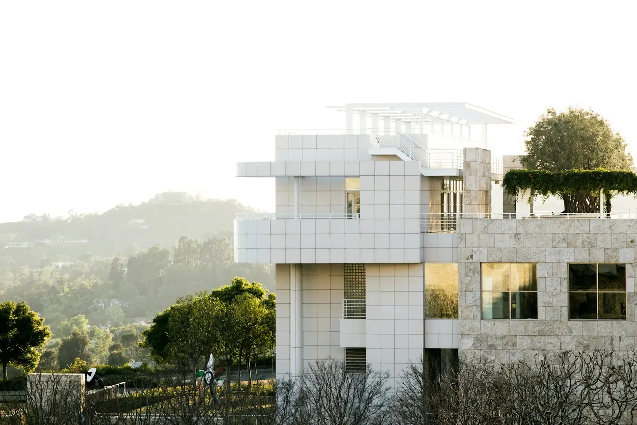 A white house on a green hillside in soft morning light