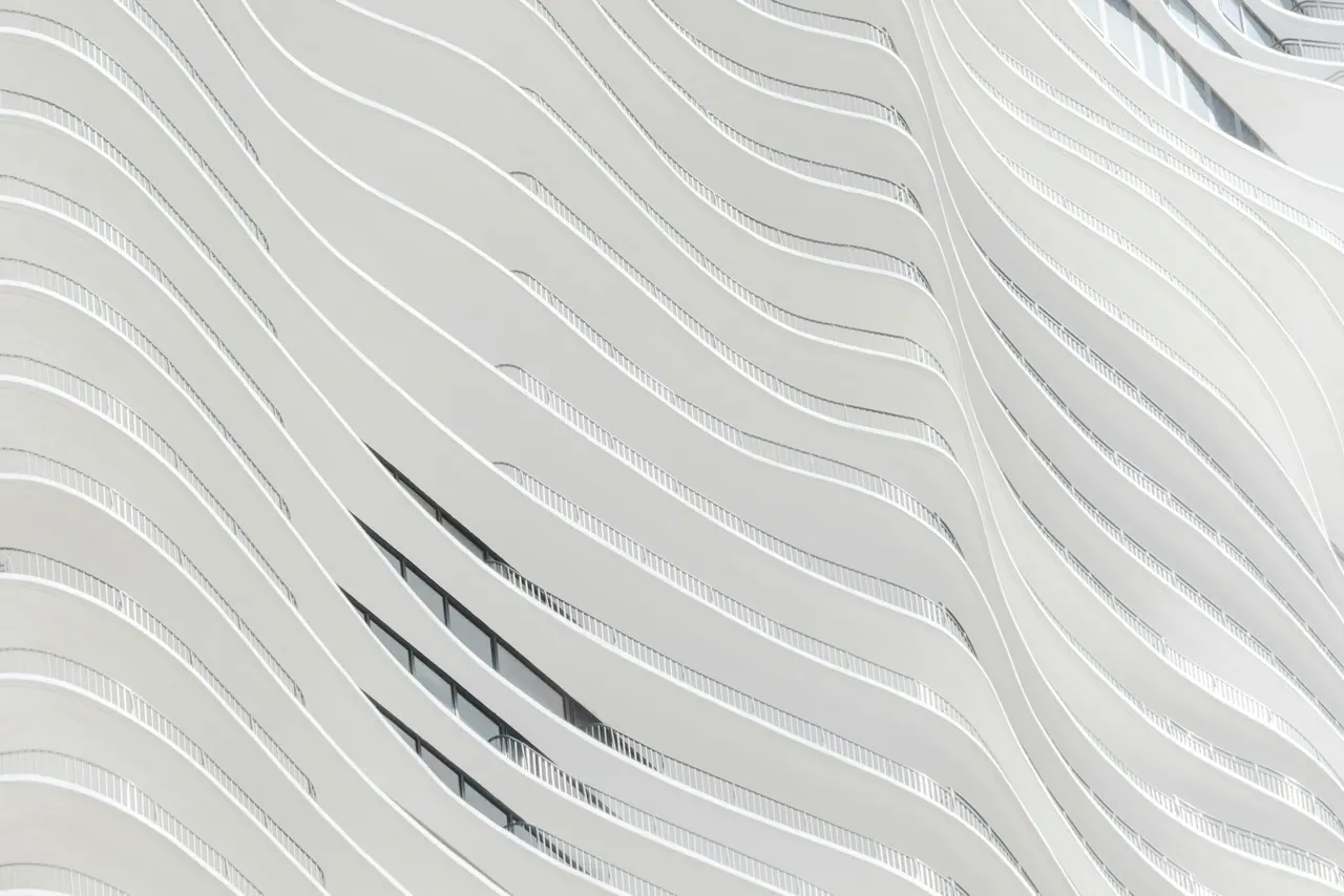 A flowing white facade of curved horizontal bands