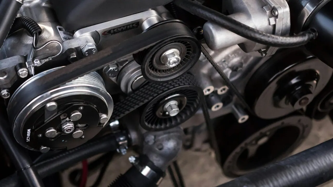 A clean engine bay with new belts and pulleys during a service