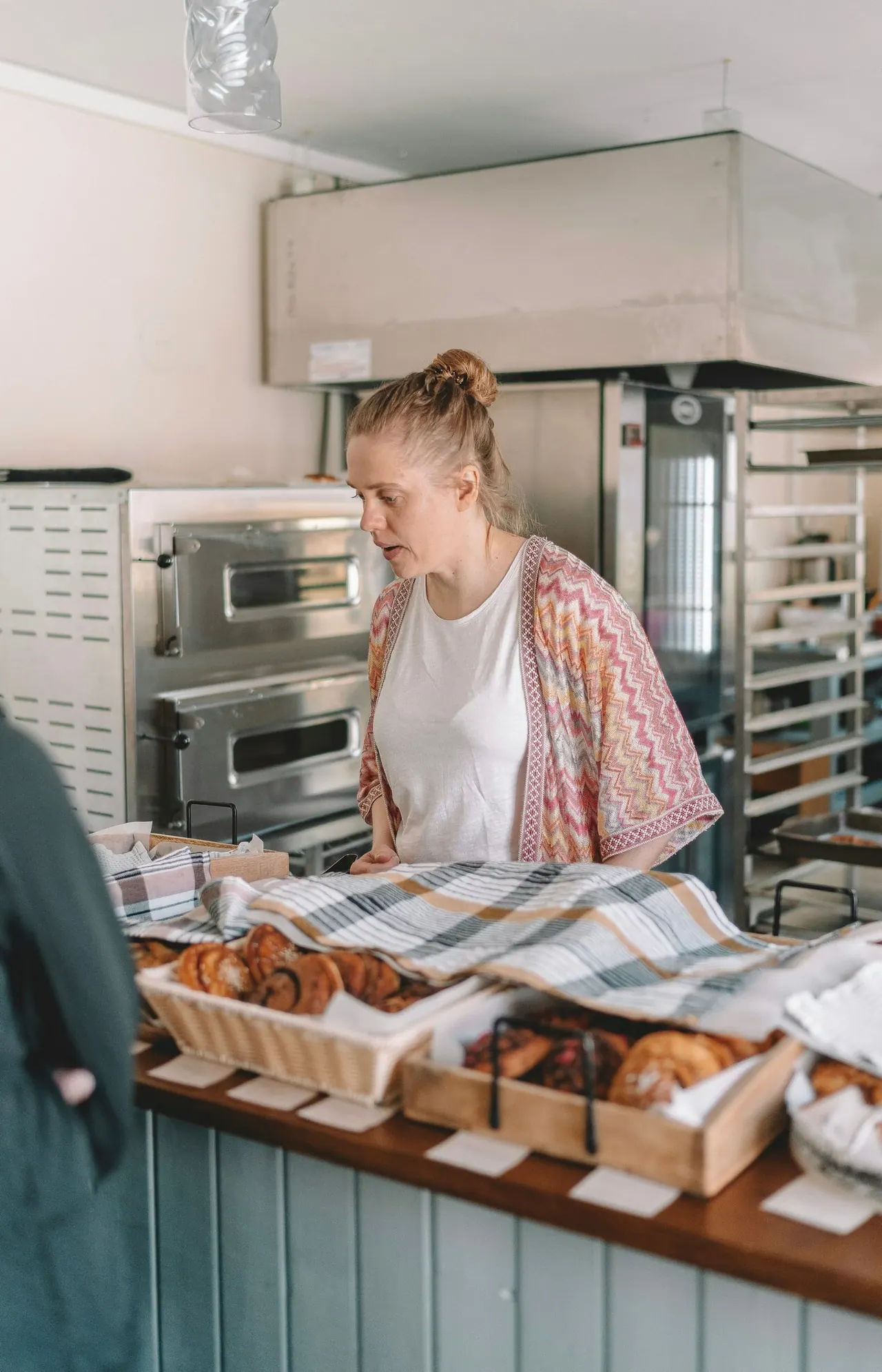 A baker checking trays of pastries at the bakery bench