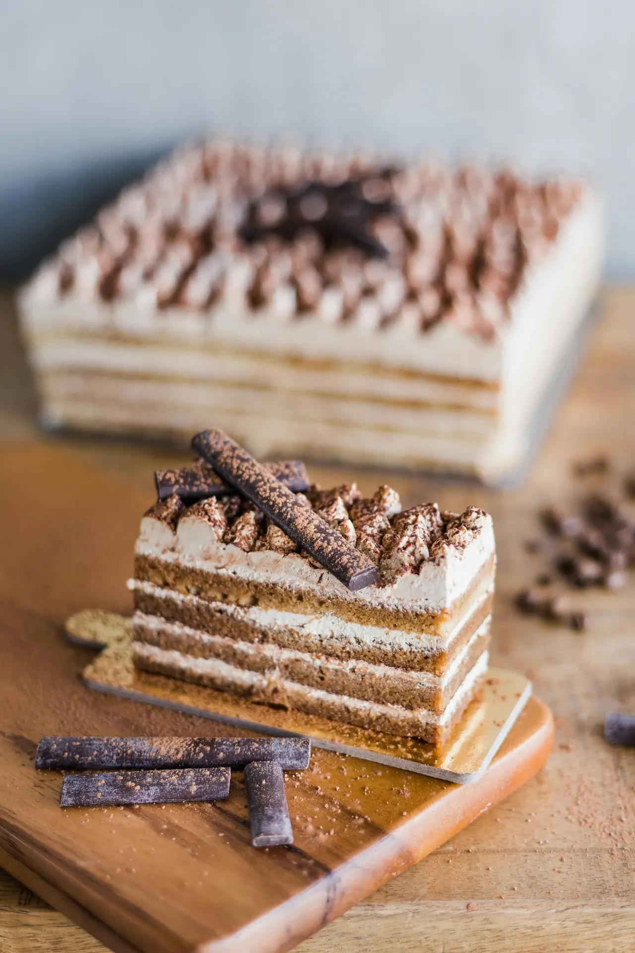 A slice of layered cake with cream and chocolate curls