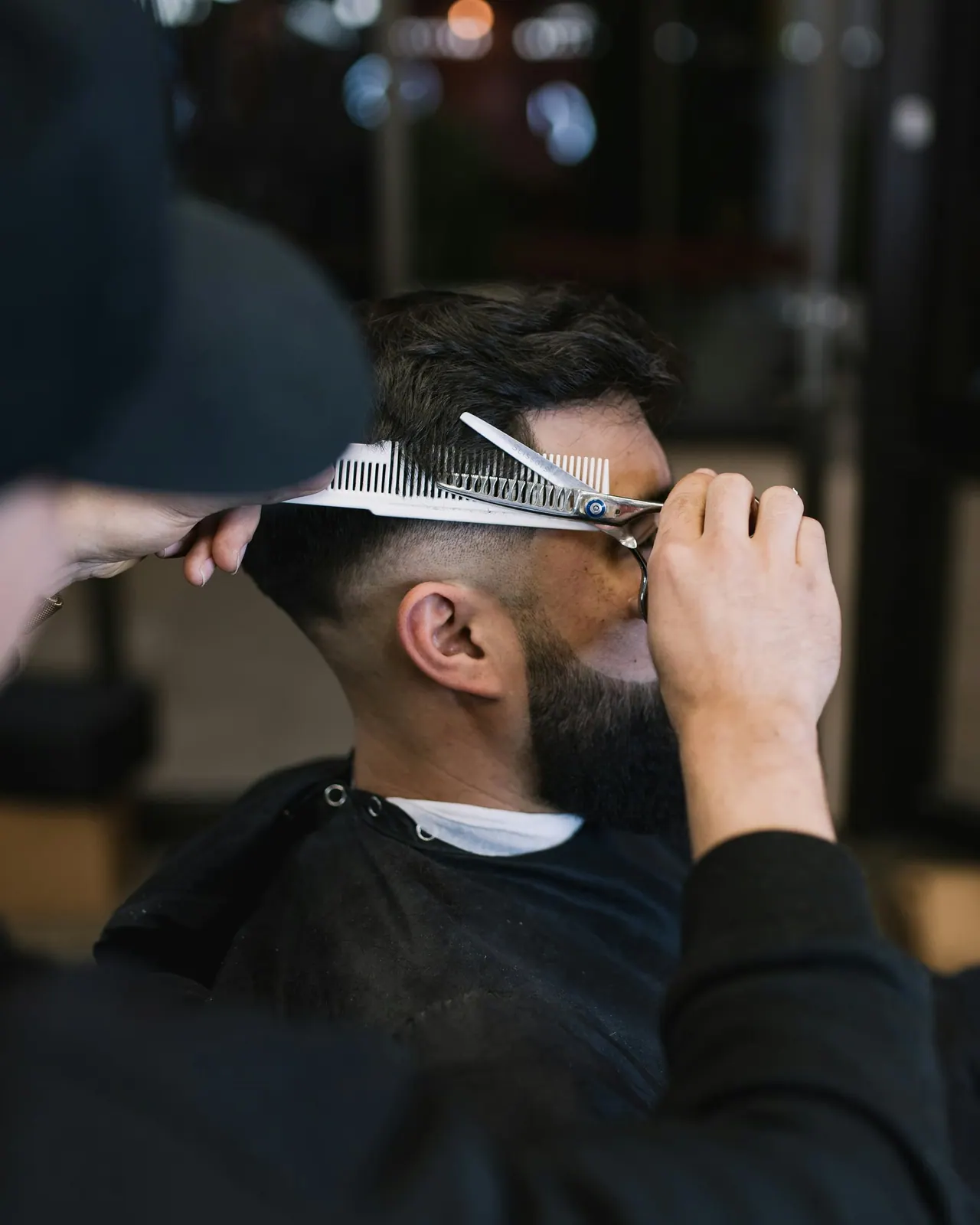 Our head barber shaping a client’s hair with scissors and a comb