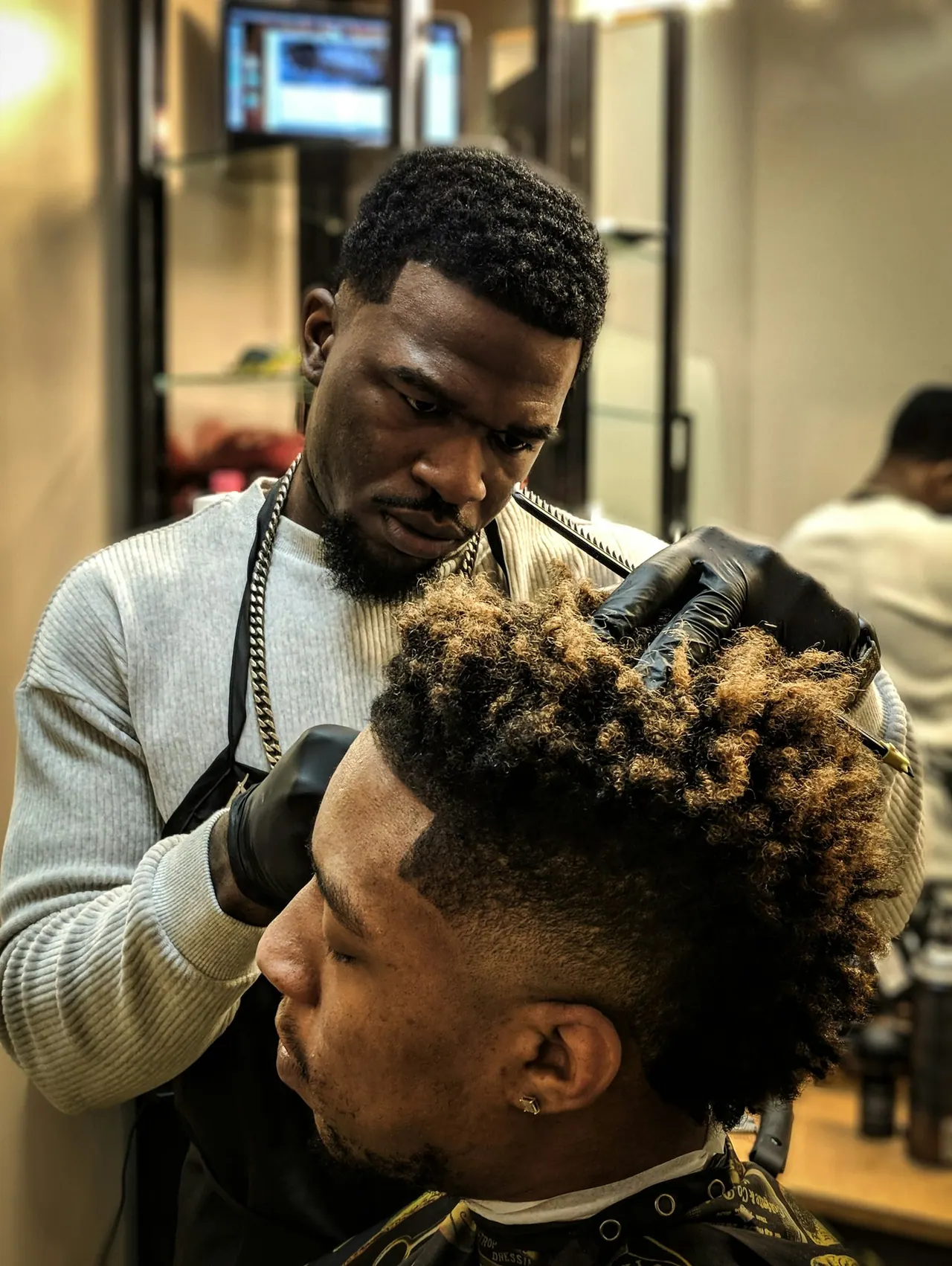 Our senior barber working on a client’s curly top