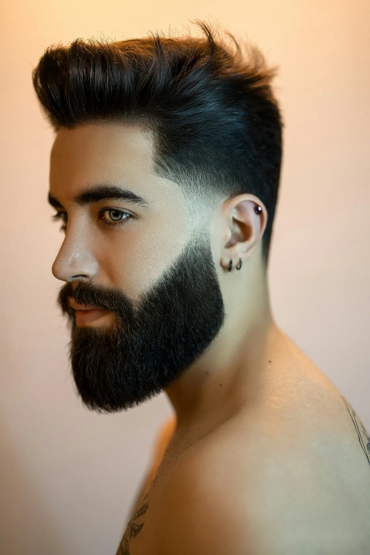 A man with a full, neatly shaped beard in profile