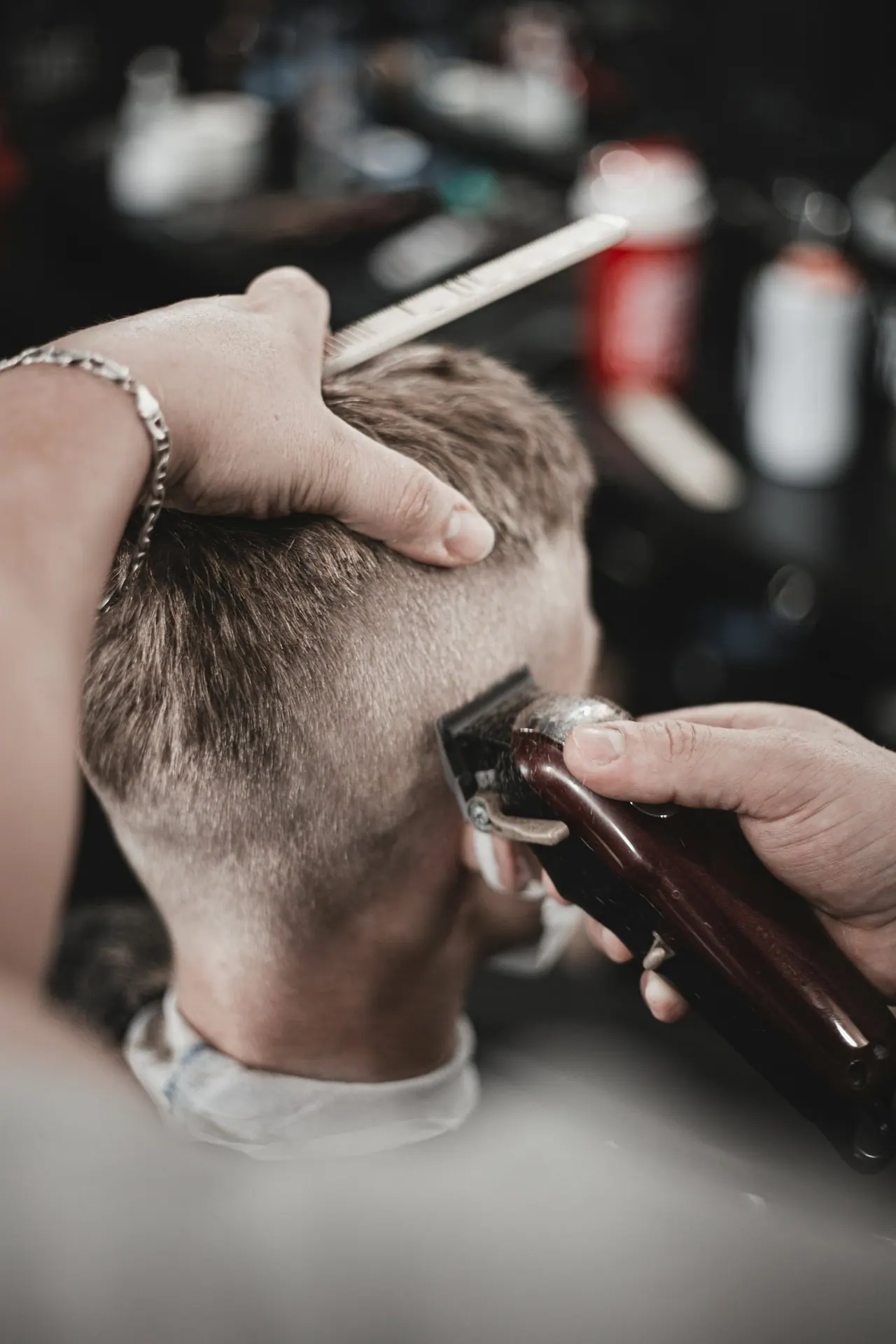 A barber running a clipper up the side of a client’s head