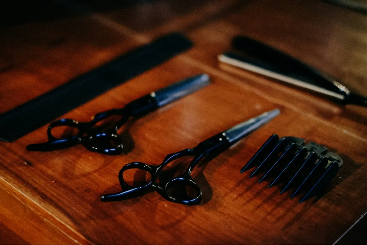 Scissors, combs and clipper guards on a walnut counter