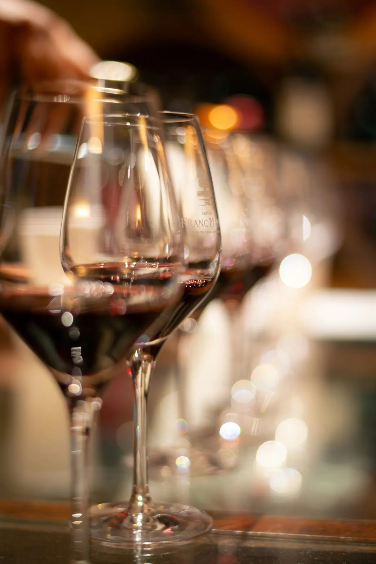 Red wine glasses lined up along the bar