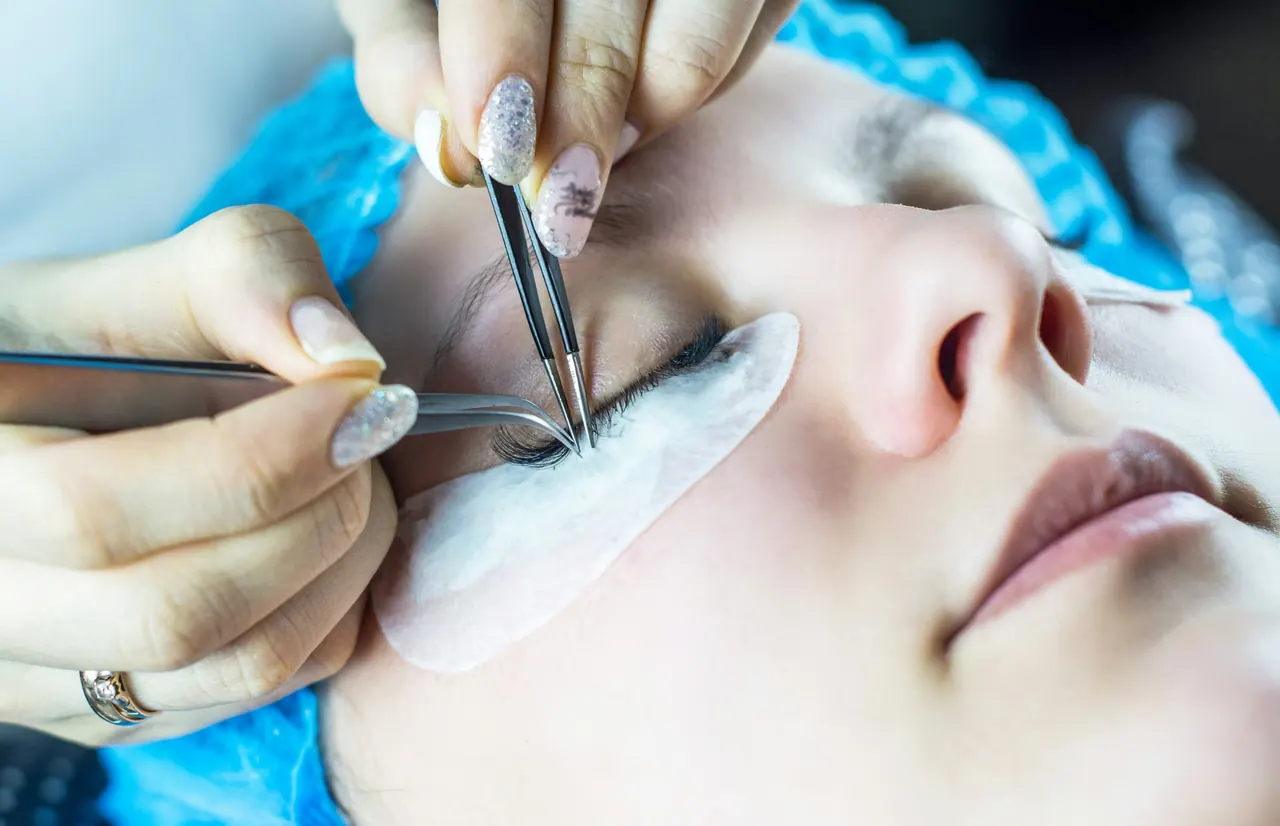 A lash artist working on a relaxed client