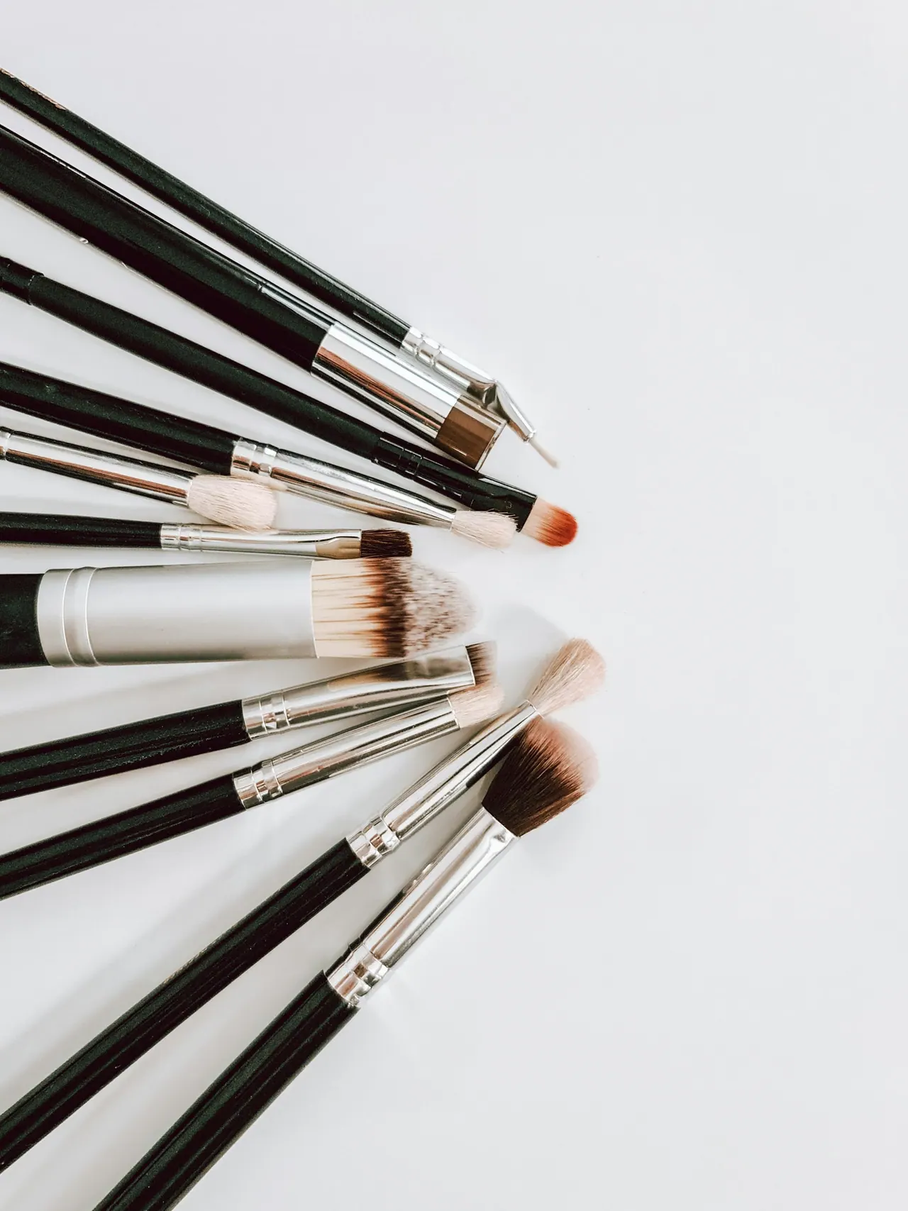 Makeup brushes fanned out on a white table