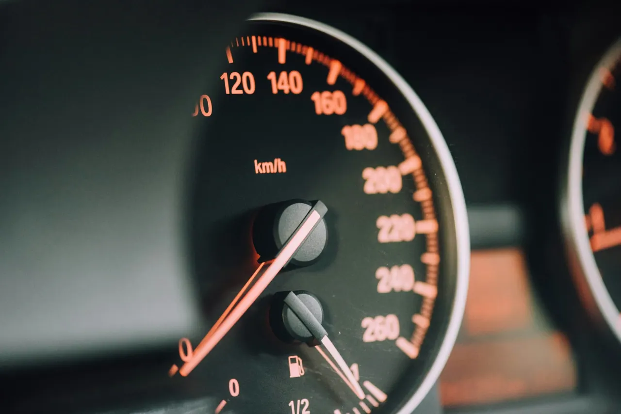 The glowing dial of a speedometer