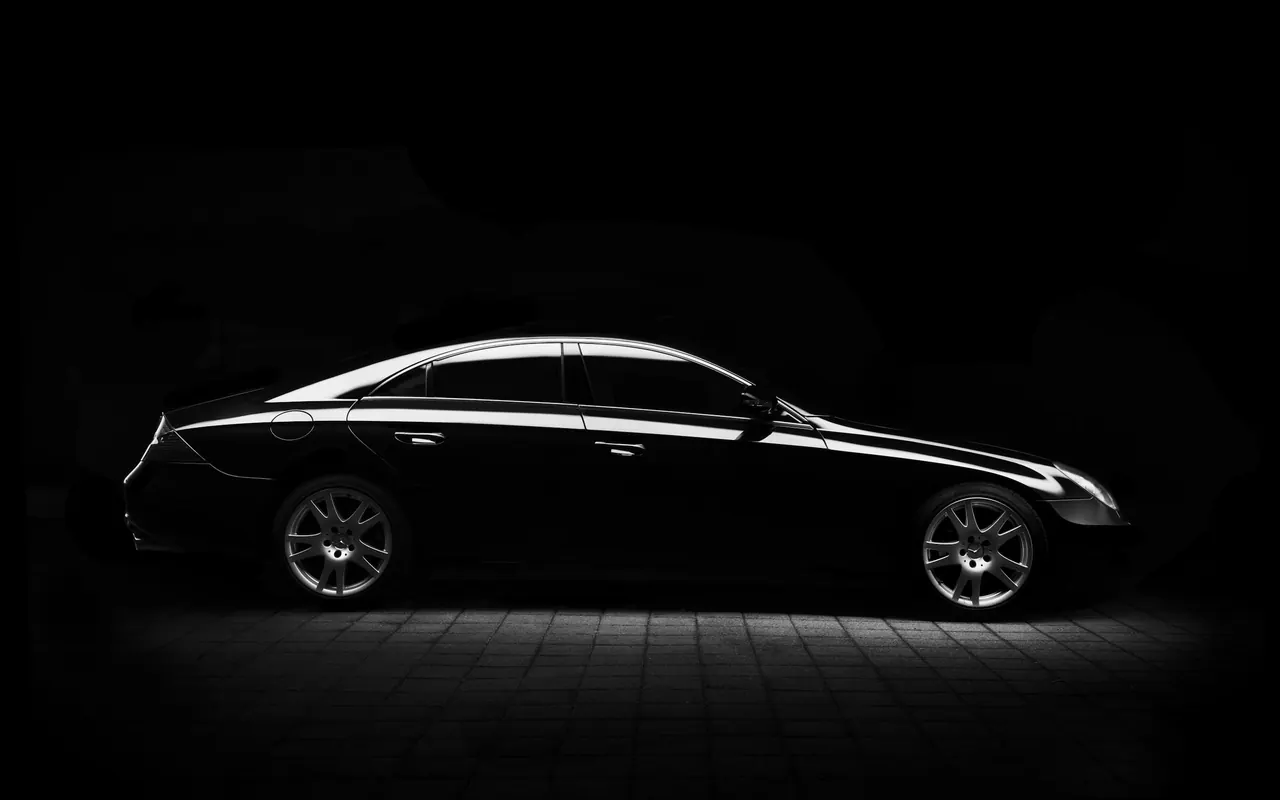 A dark executive sedan in a studio, seen from the side