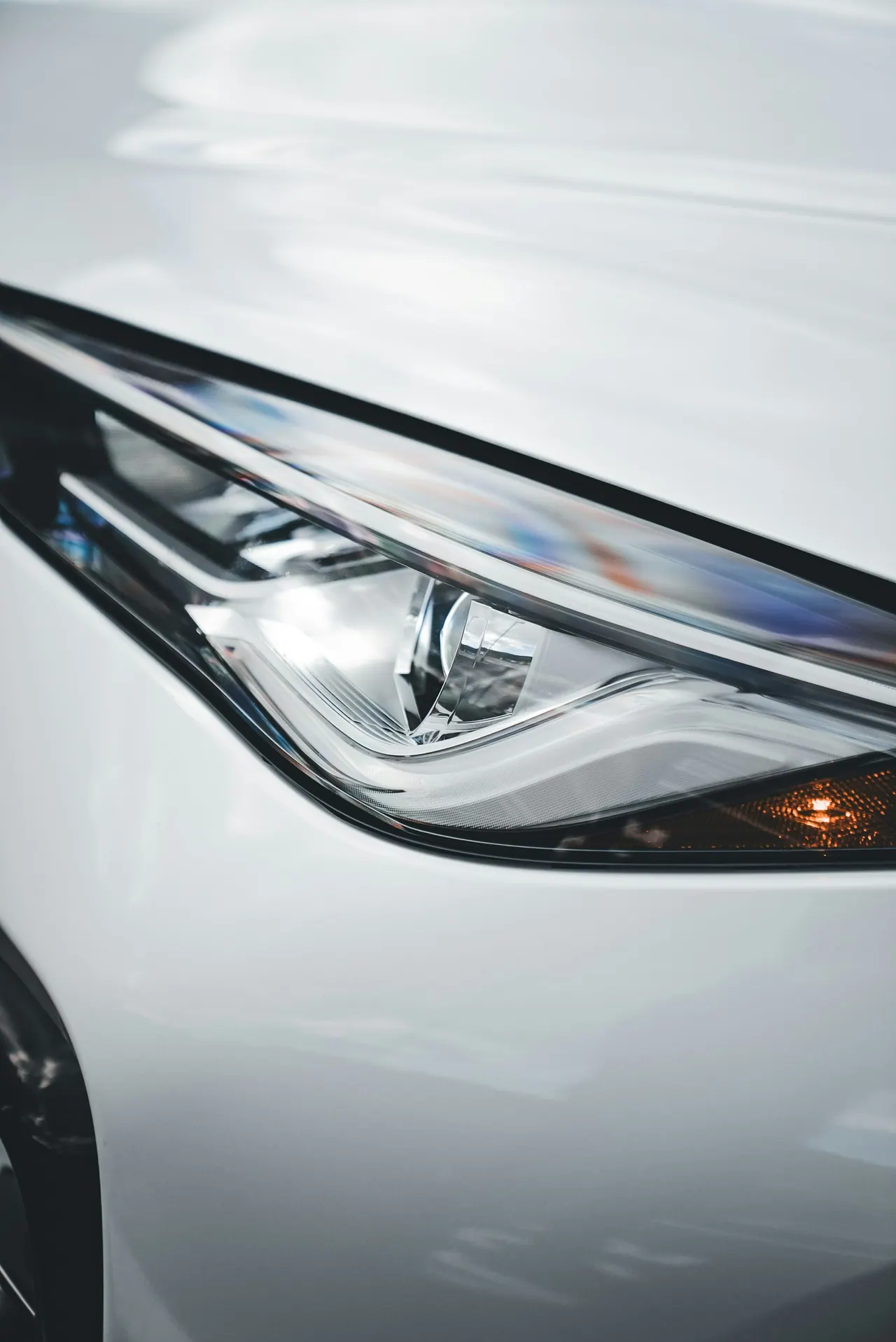 The sleek LED headlight of a white midsize SUV