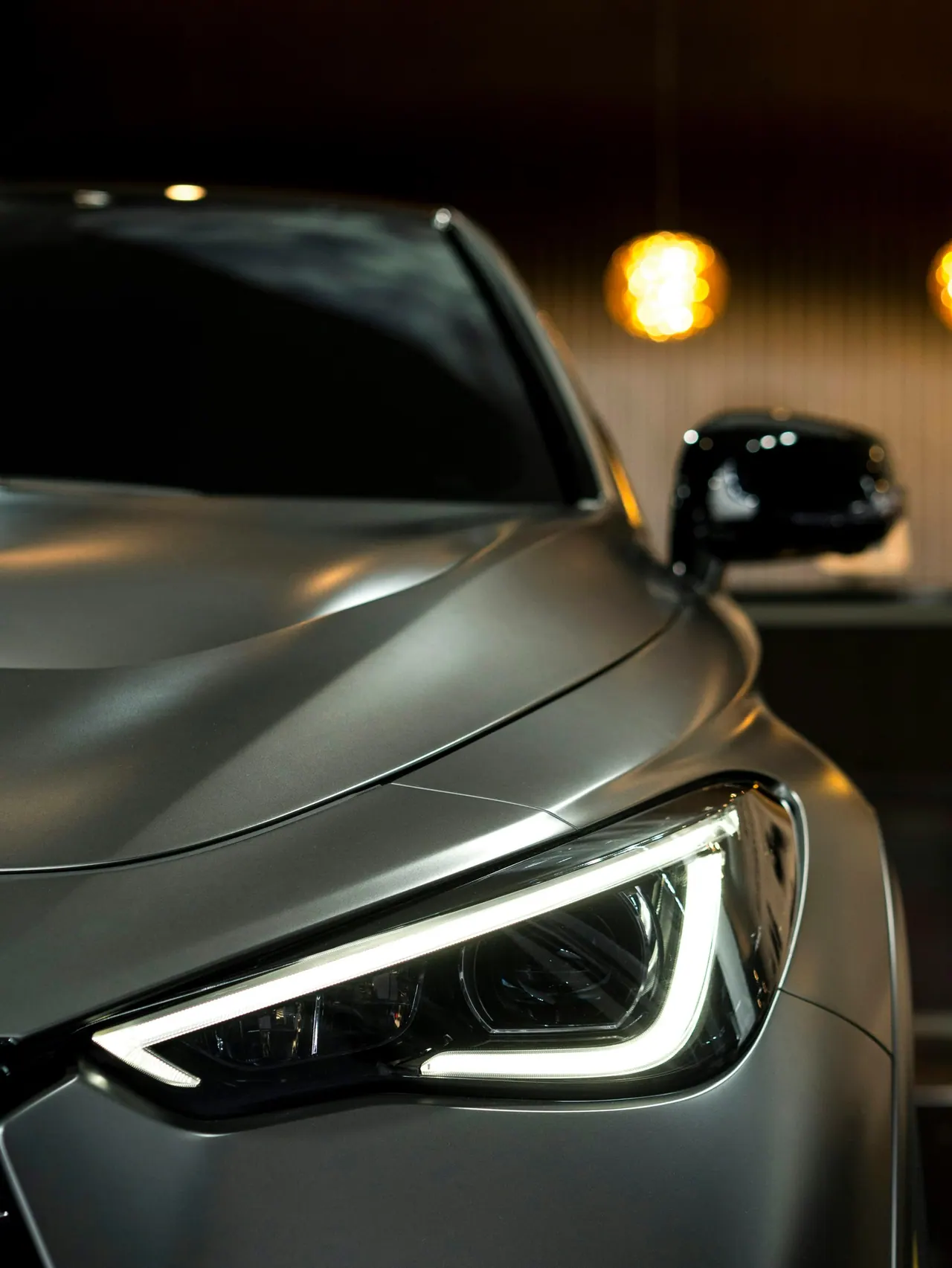 The front of a silver crossover at night