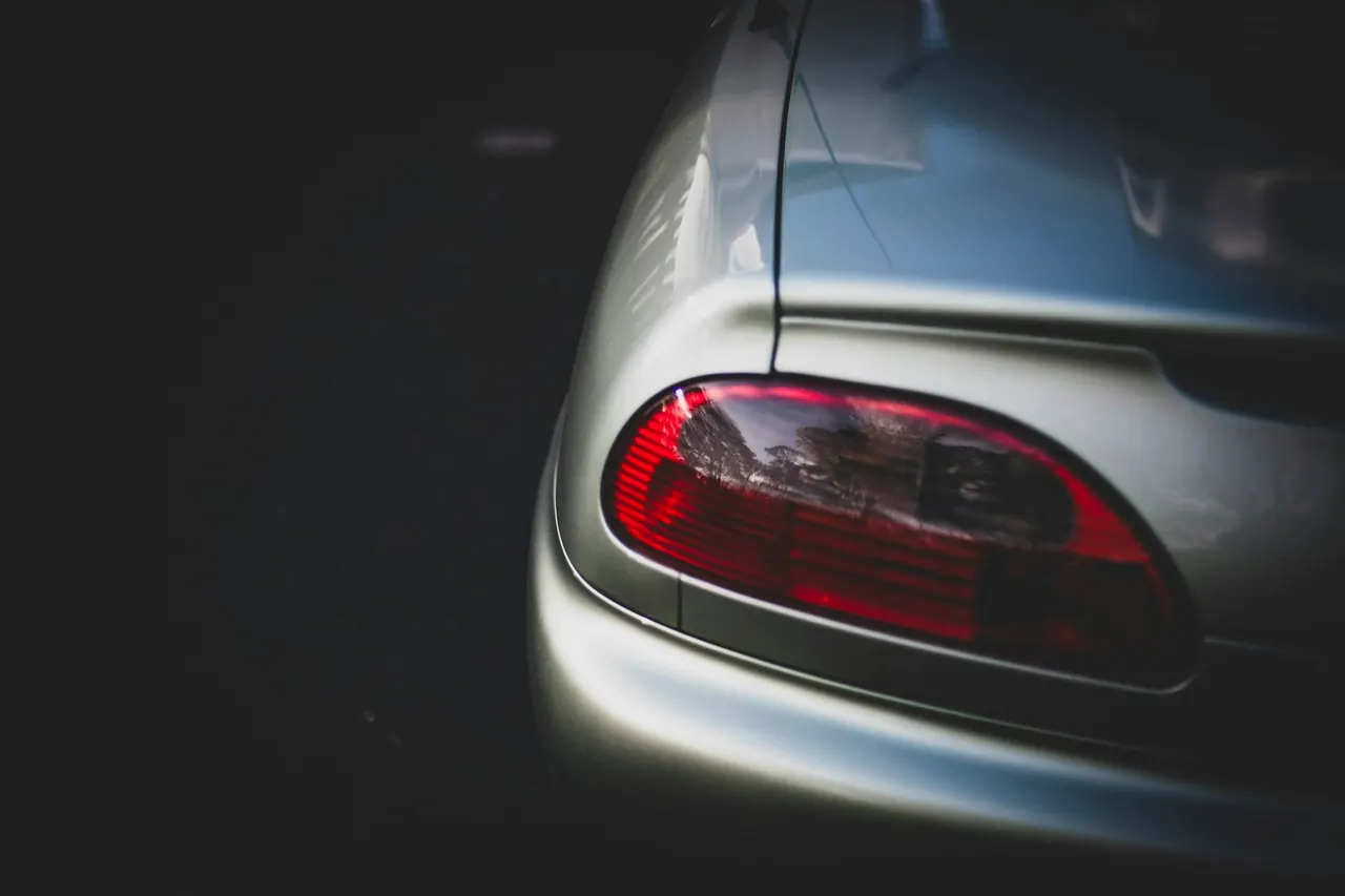 A silver car tail light glowing red