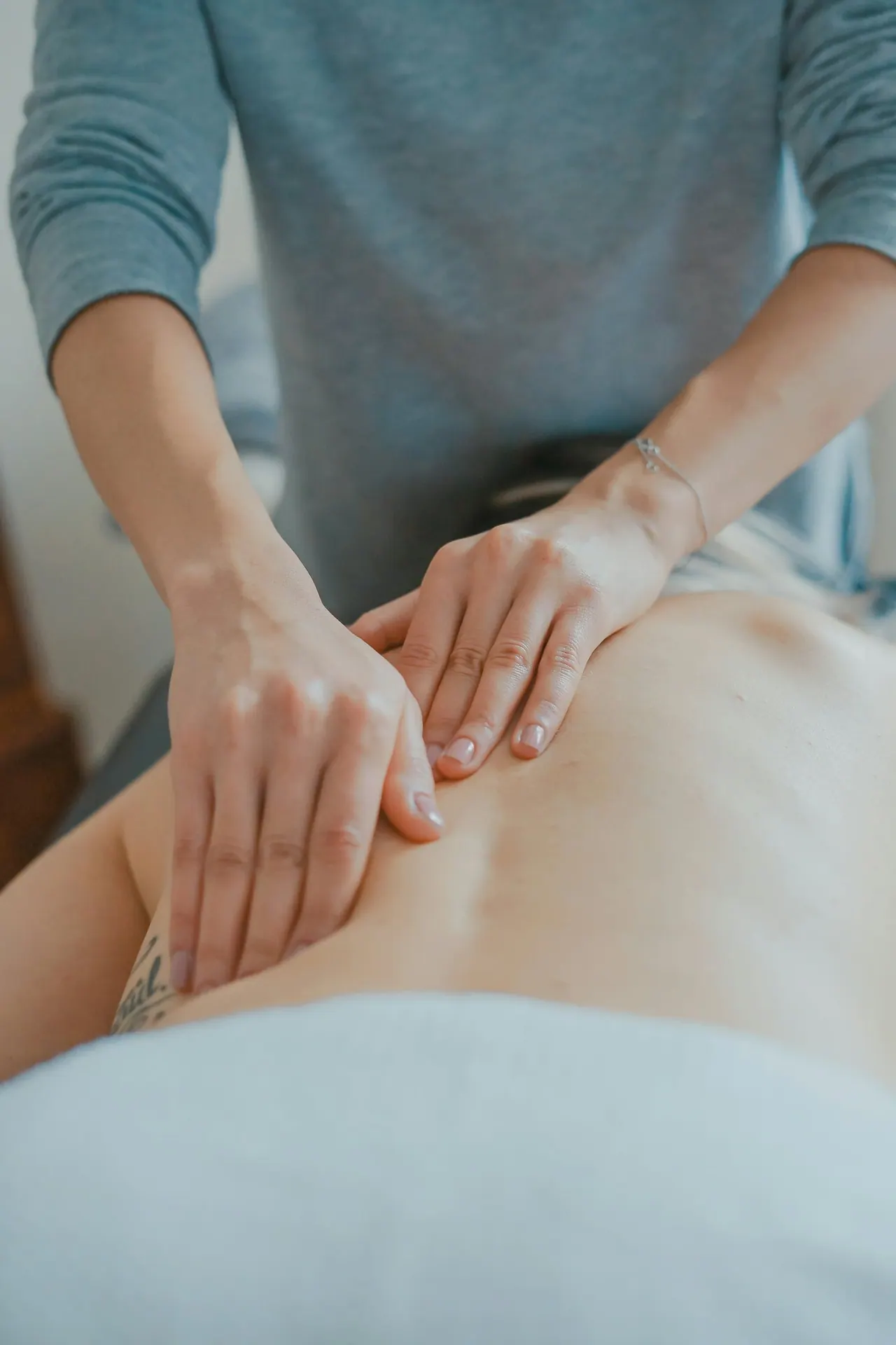 A chiropractor's hands working along a patient's back