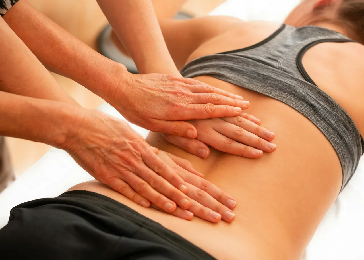 A chiropractor's hands working gently on a patient's lower back