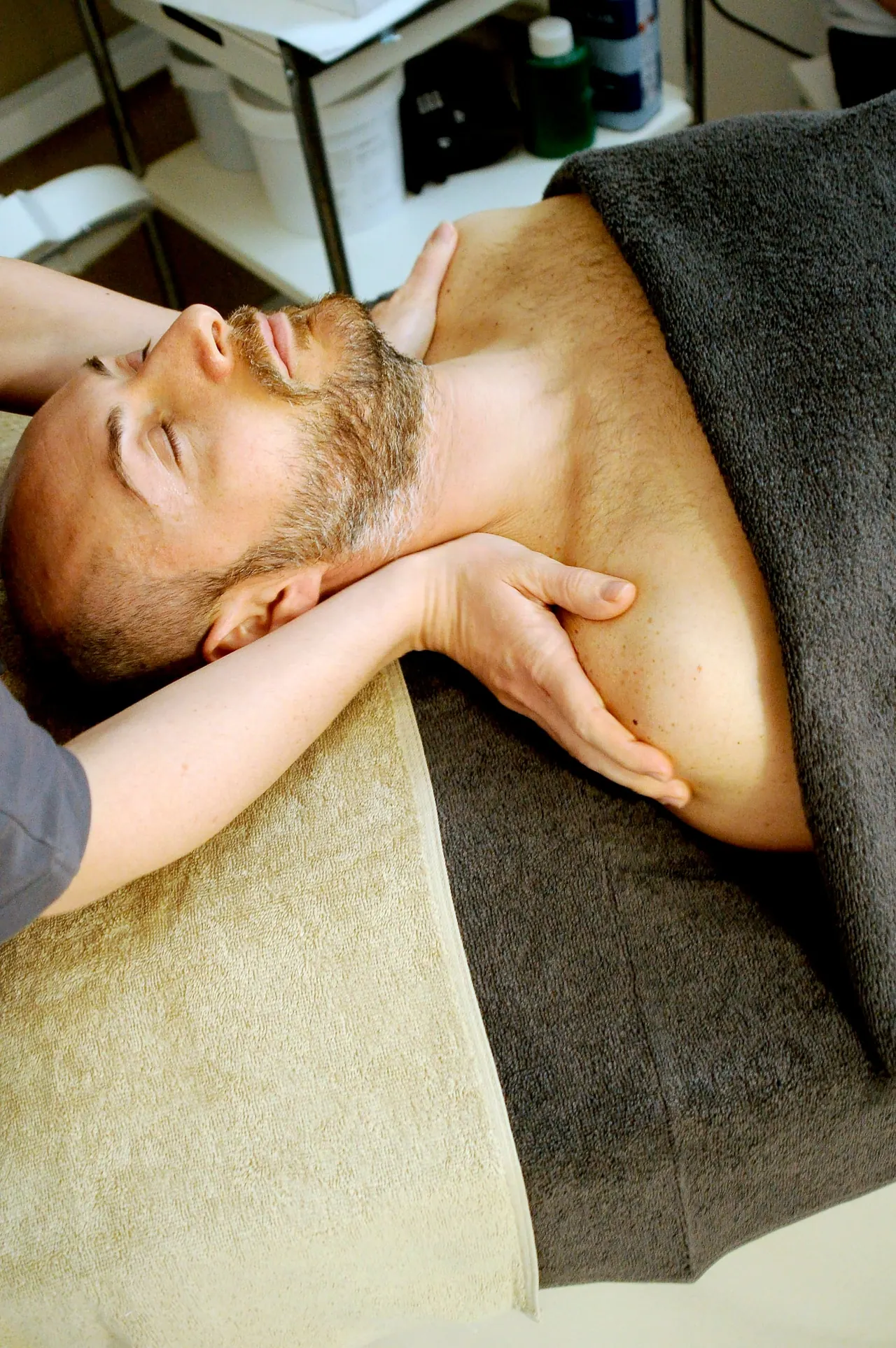 A man resting on a treatment table during a gentle neck treatment
