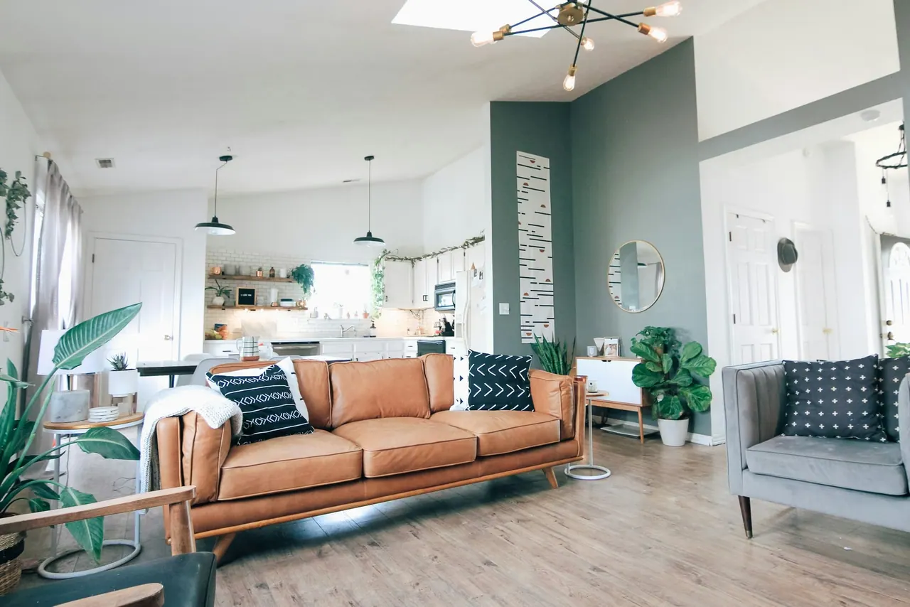 A bright, freshly cleaned living room with a leather sofa and sunlight from a skylight