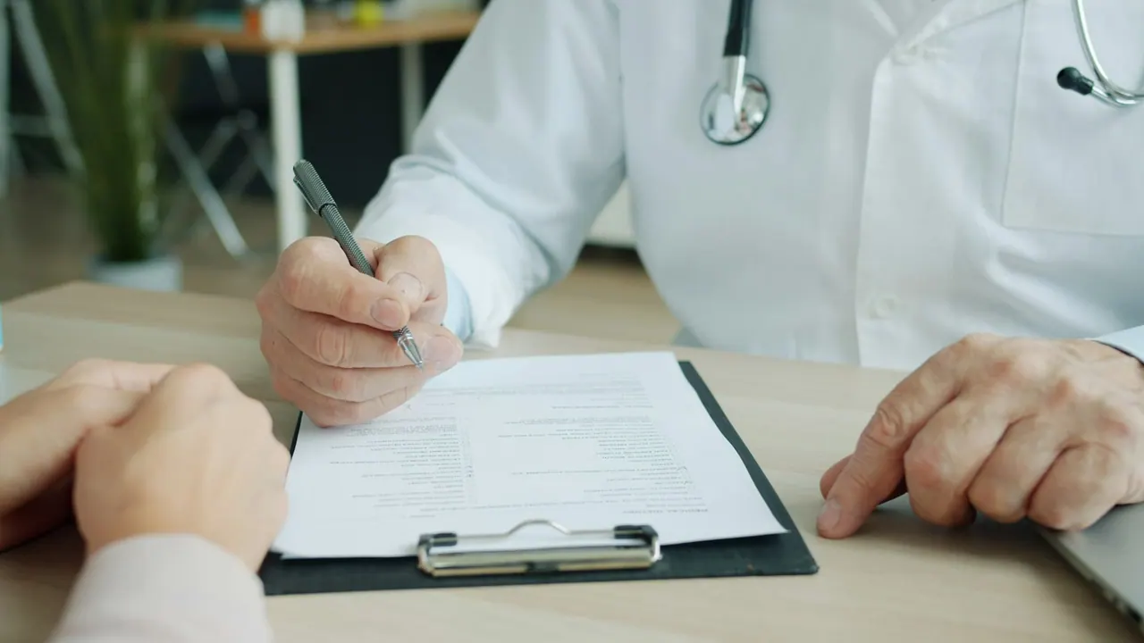 A doctor writing notes on a clipboard with a patient