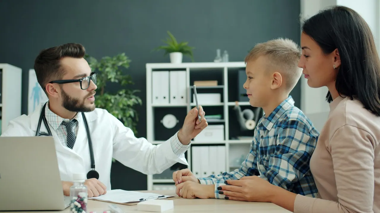 A doctor talking with a young boy and his mother