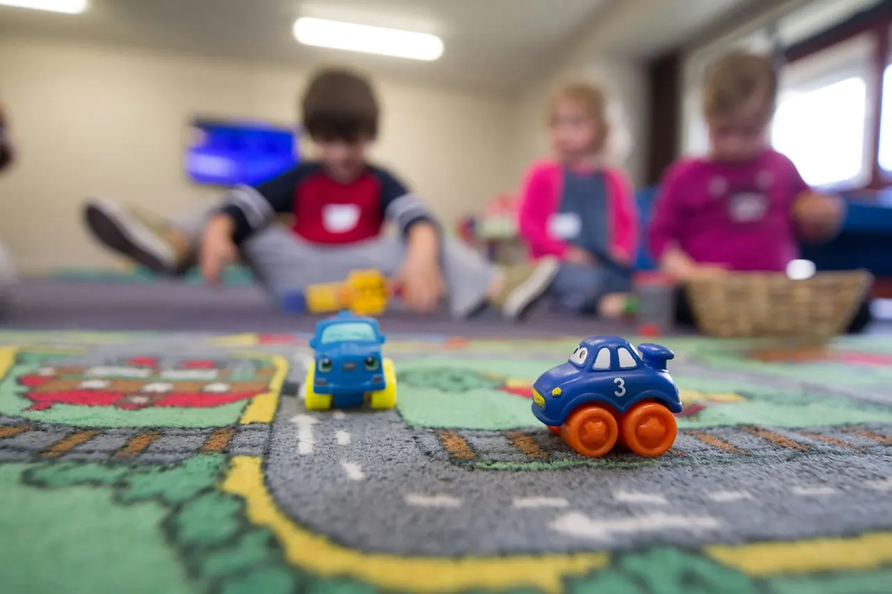 Little ones playing with toy cars on a play mat