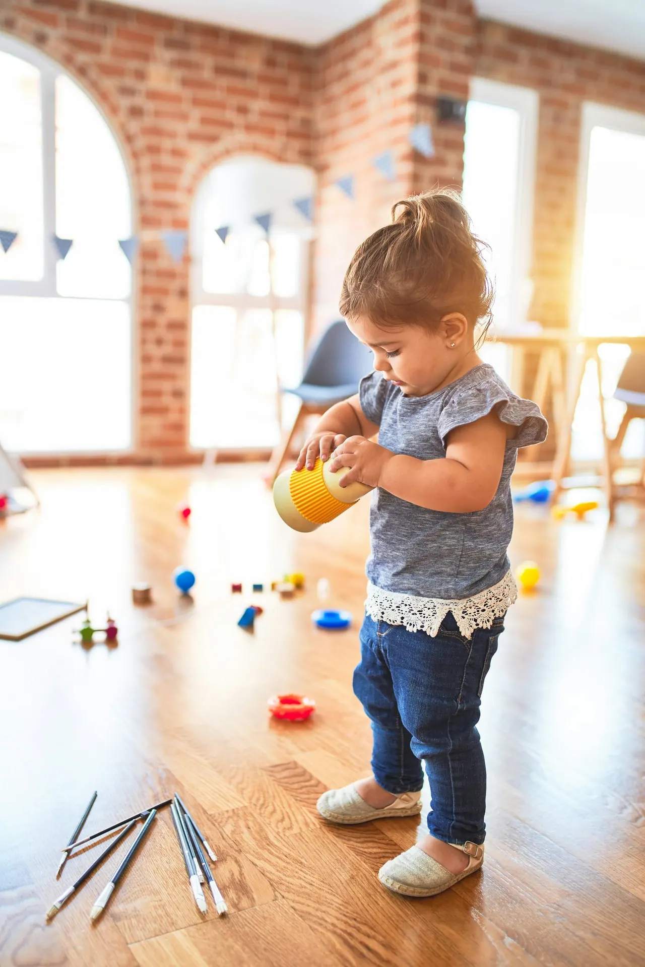 A toddler playing in a sunlit room