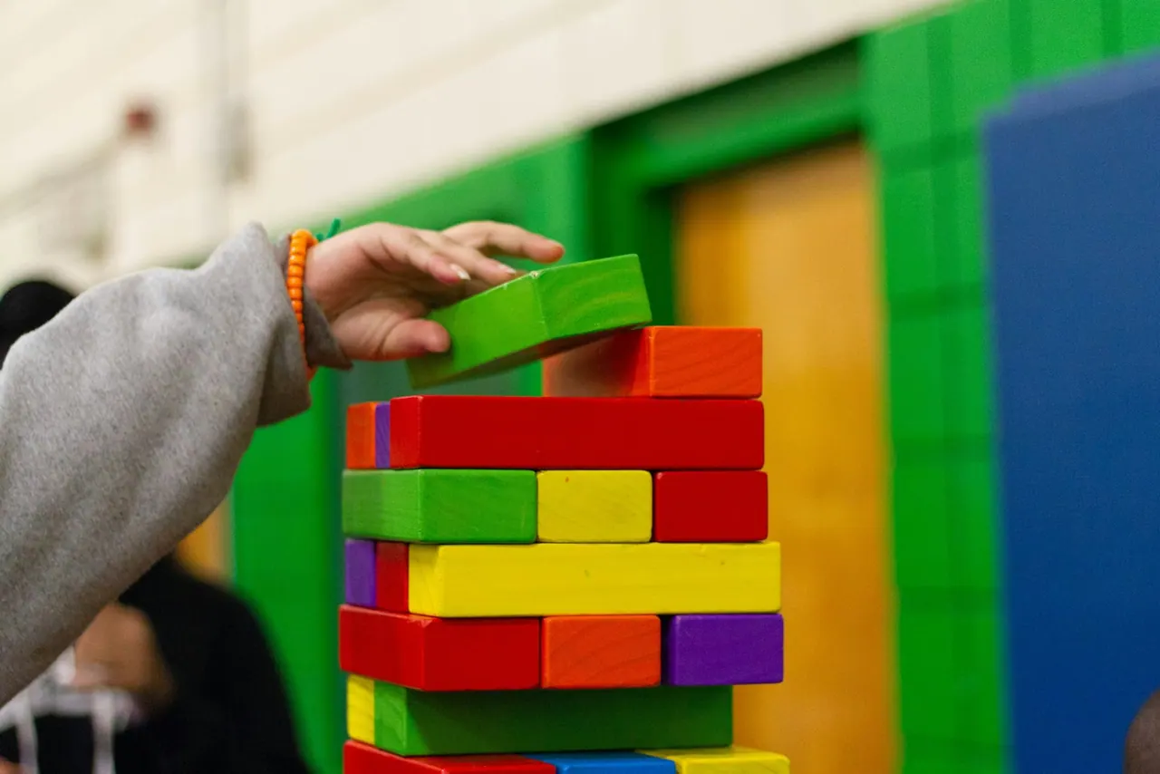 A child stacking bright wooden blocks into a tower