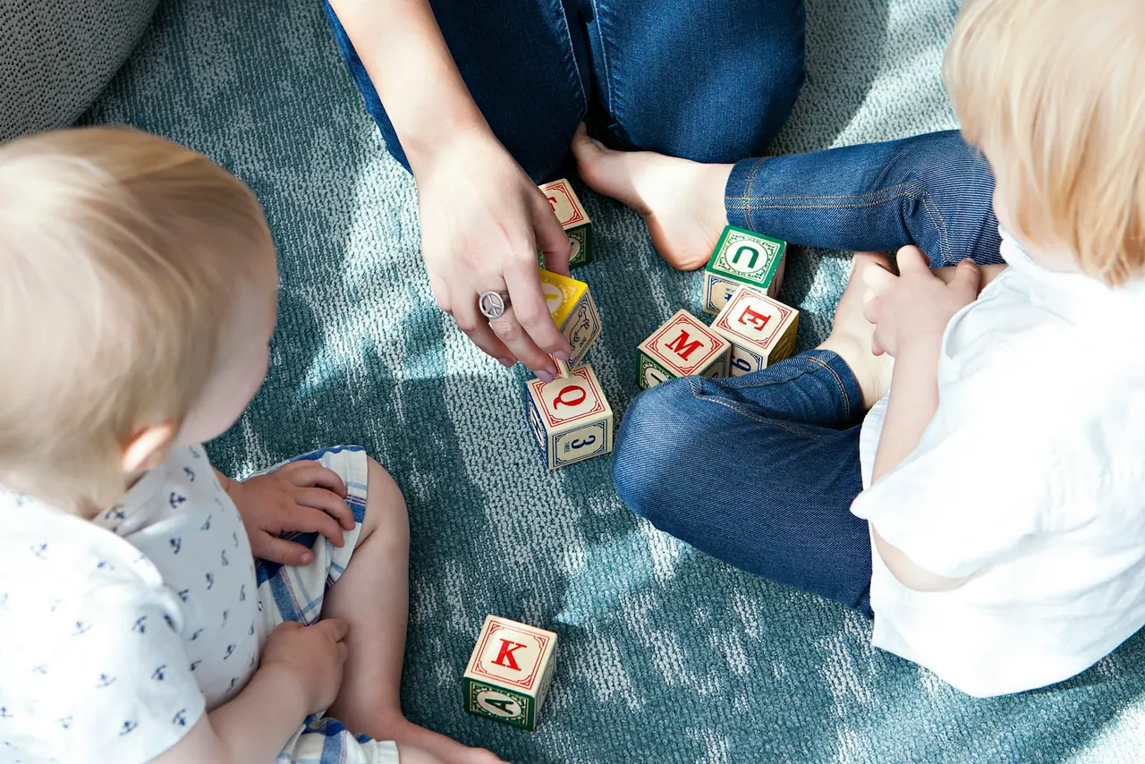 Toddlers playing with wooden letter cubes