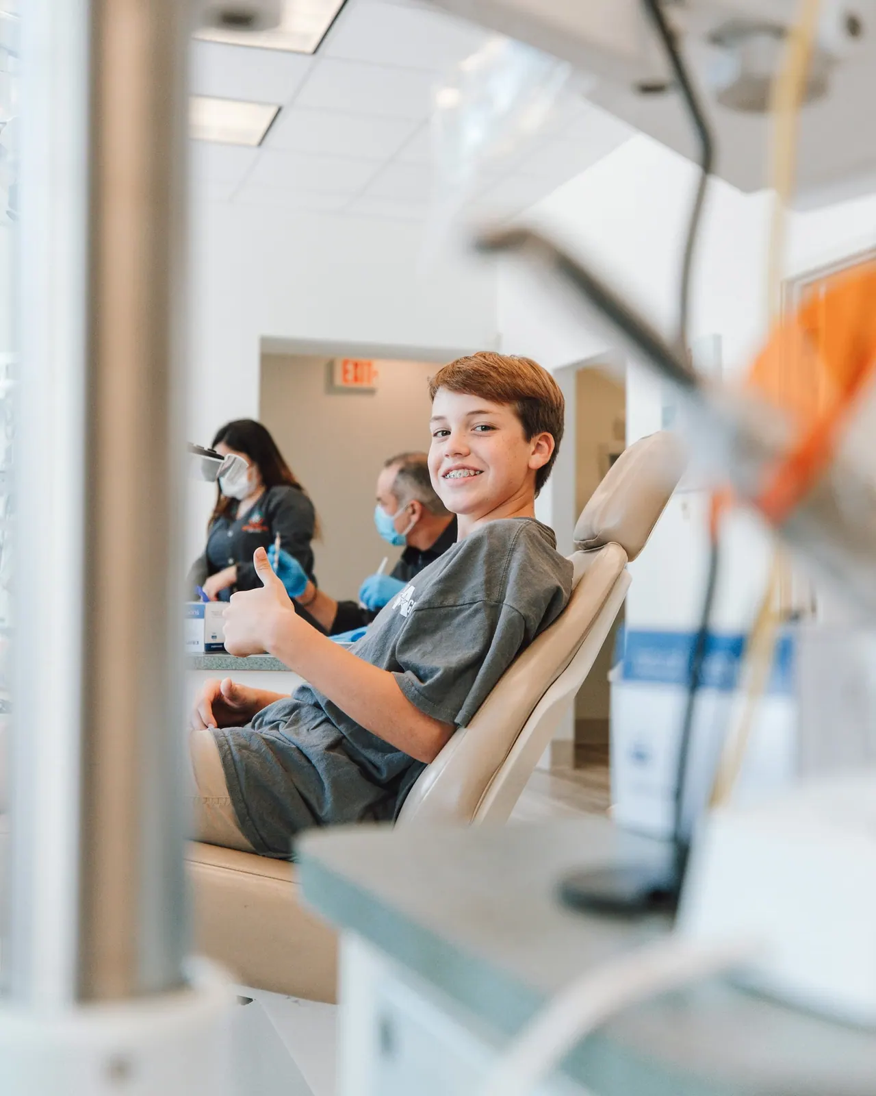 A boy giving a thumbs up from the dental chair