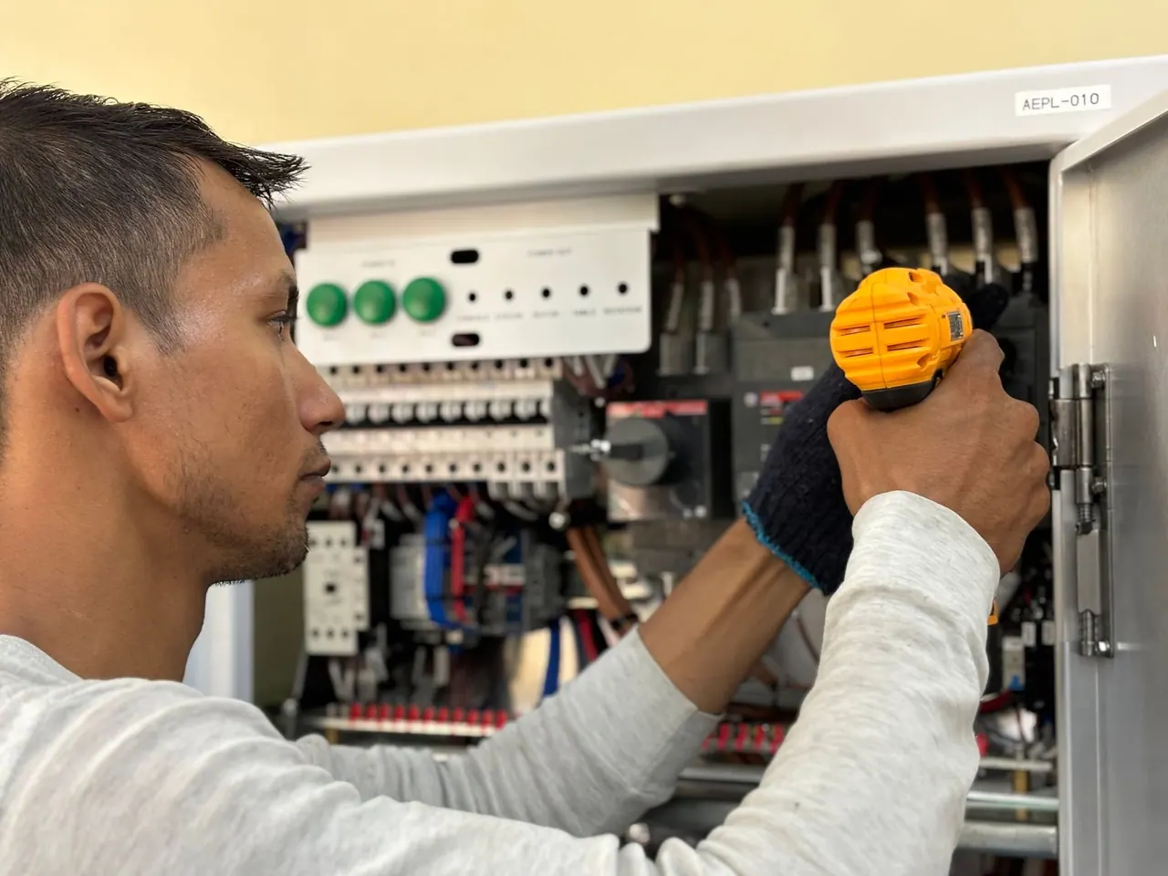 An electrician testing a breaker panel