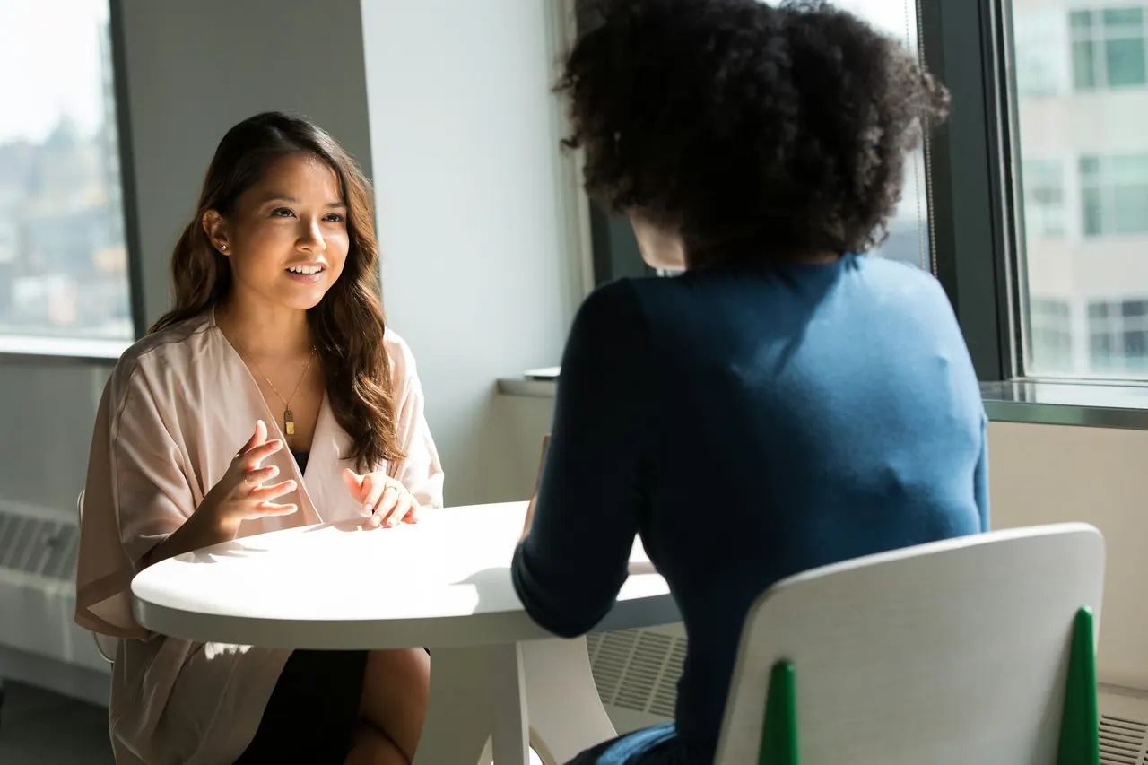 A financial planner talking a client through her plan at a sunny window table