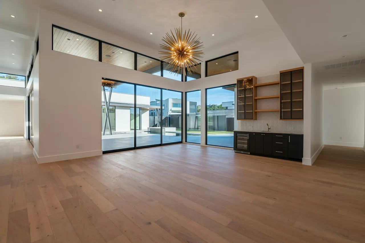 A wide open room with new oak floors and tall windows