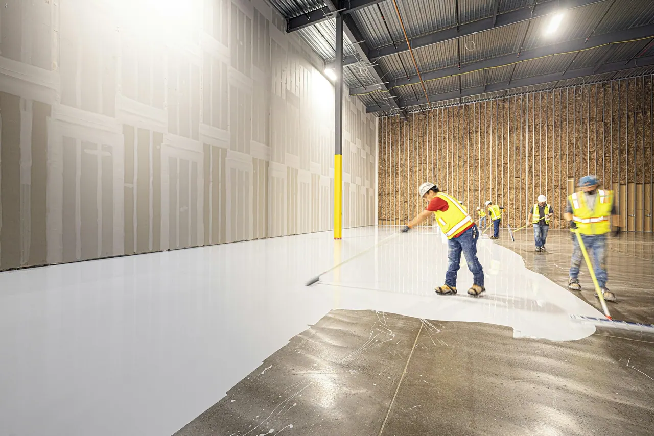 A crew coating a large warehouse floor