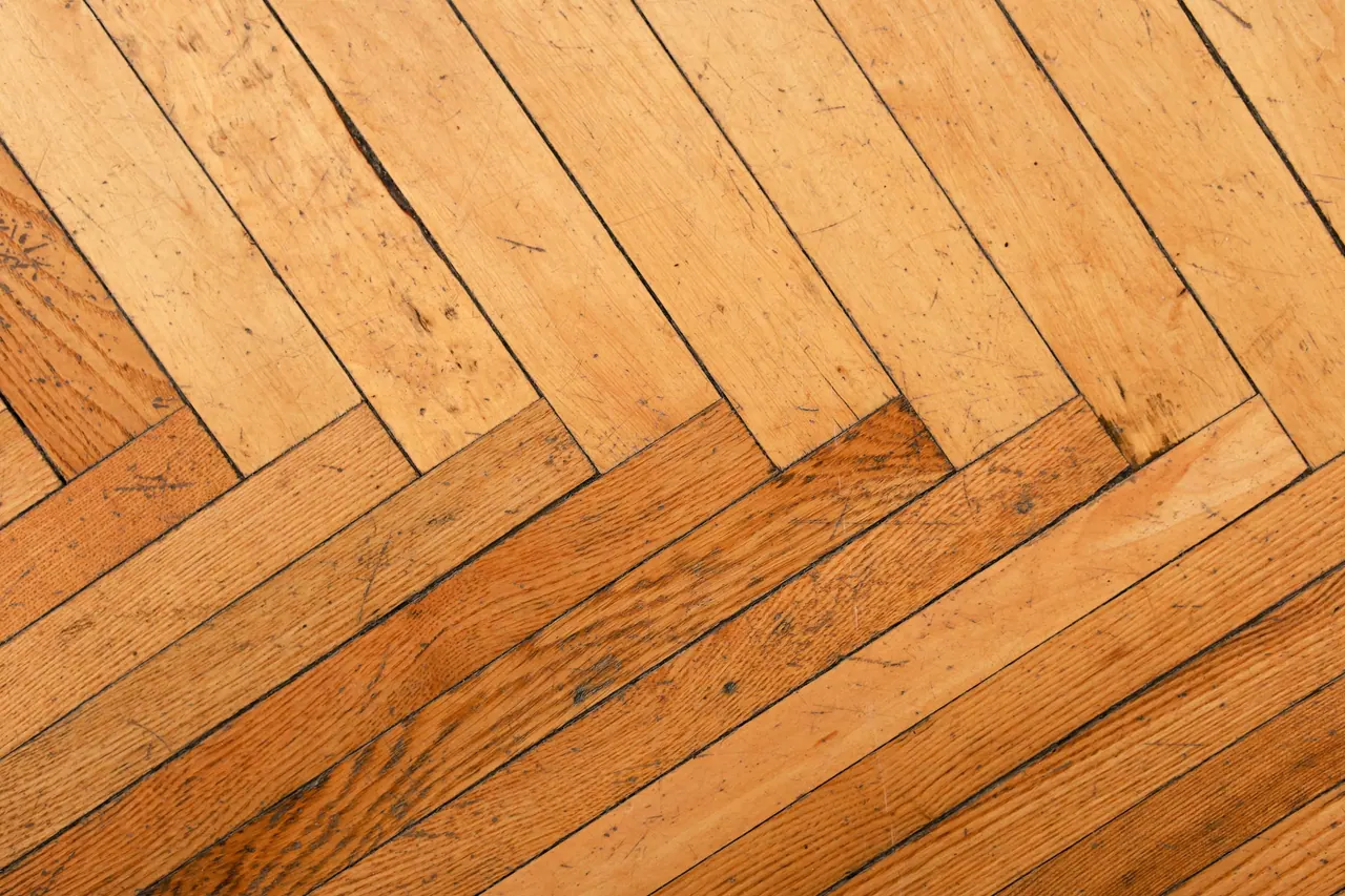 A worn herringbone wood floor with its old patina