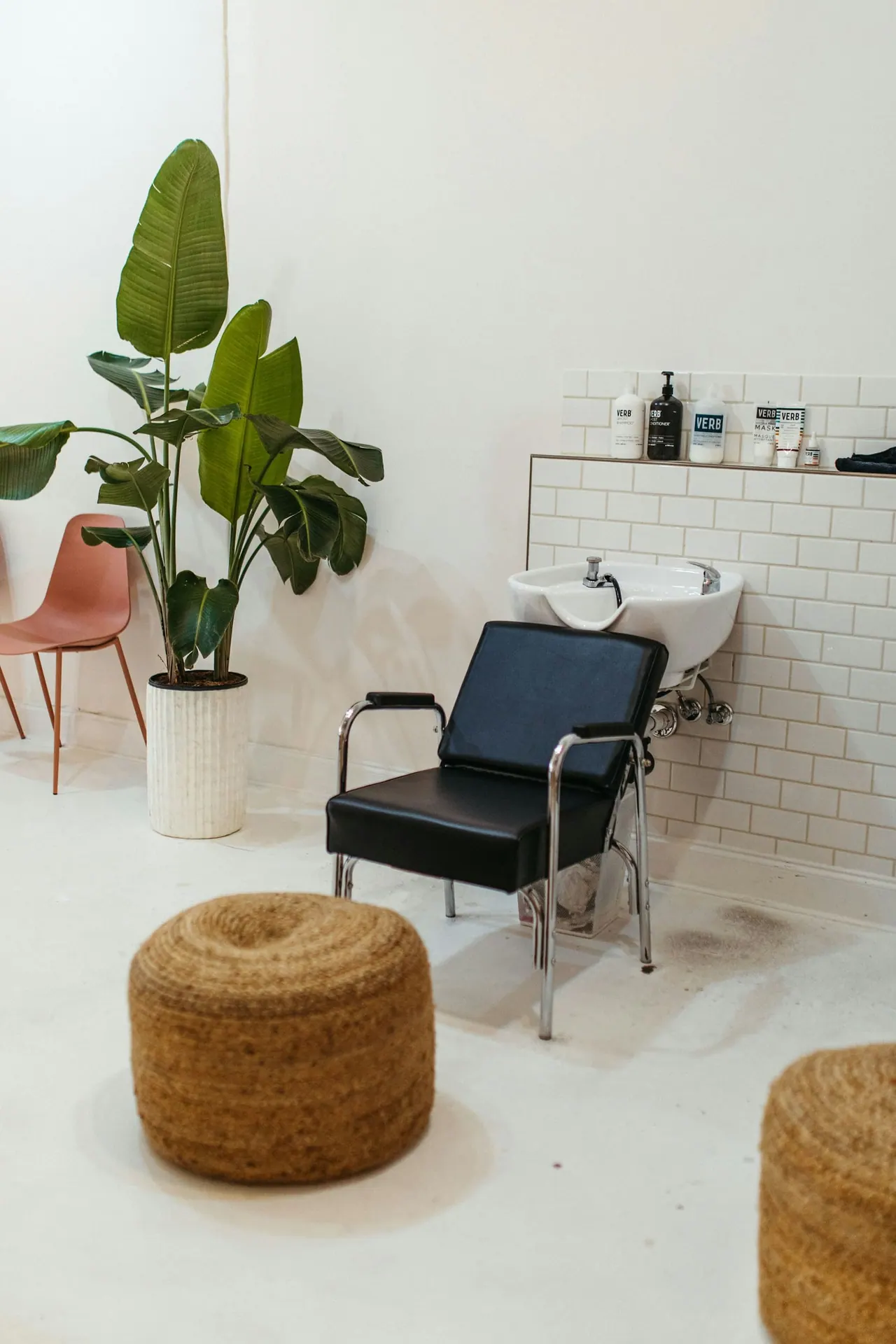 A bright wash station with a black chair and a leafy plant