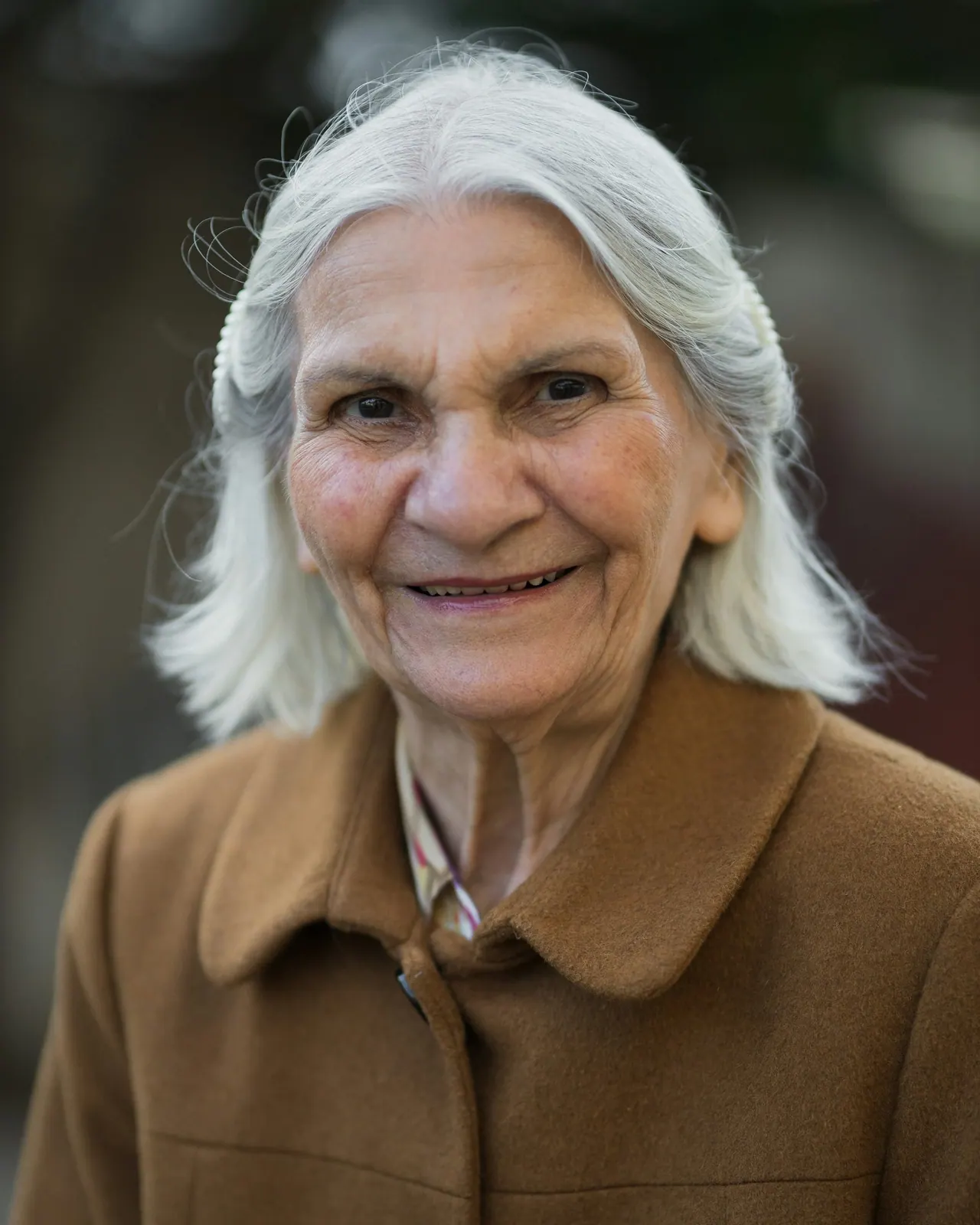 A smiling older woman with long white hair