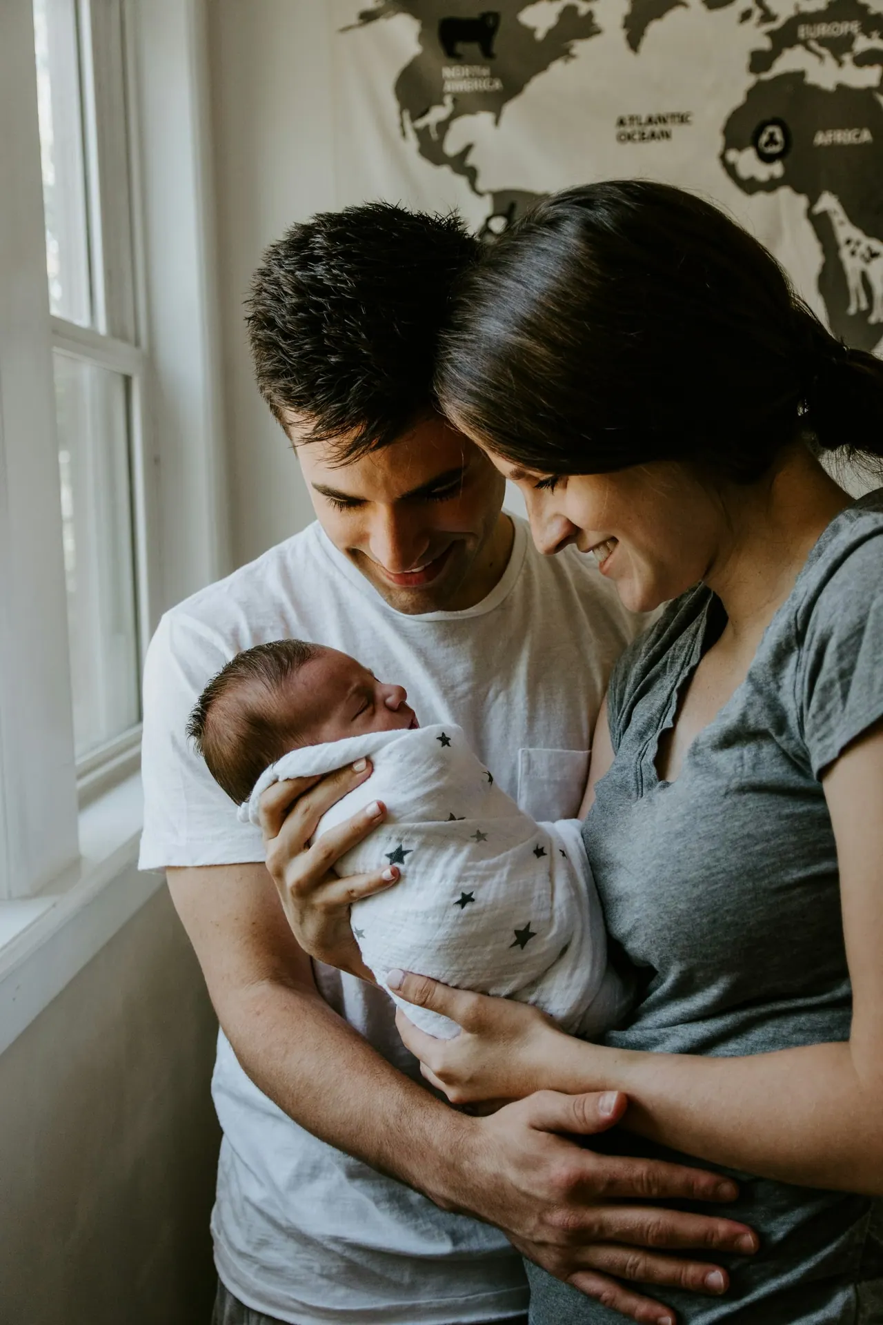 A young family at home, a mother holding her baby beside her partner