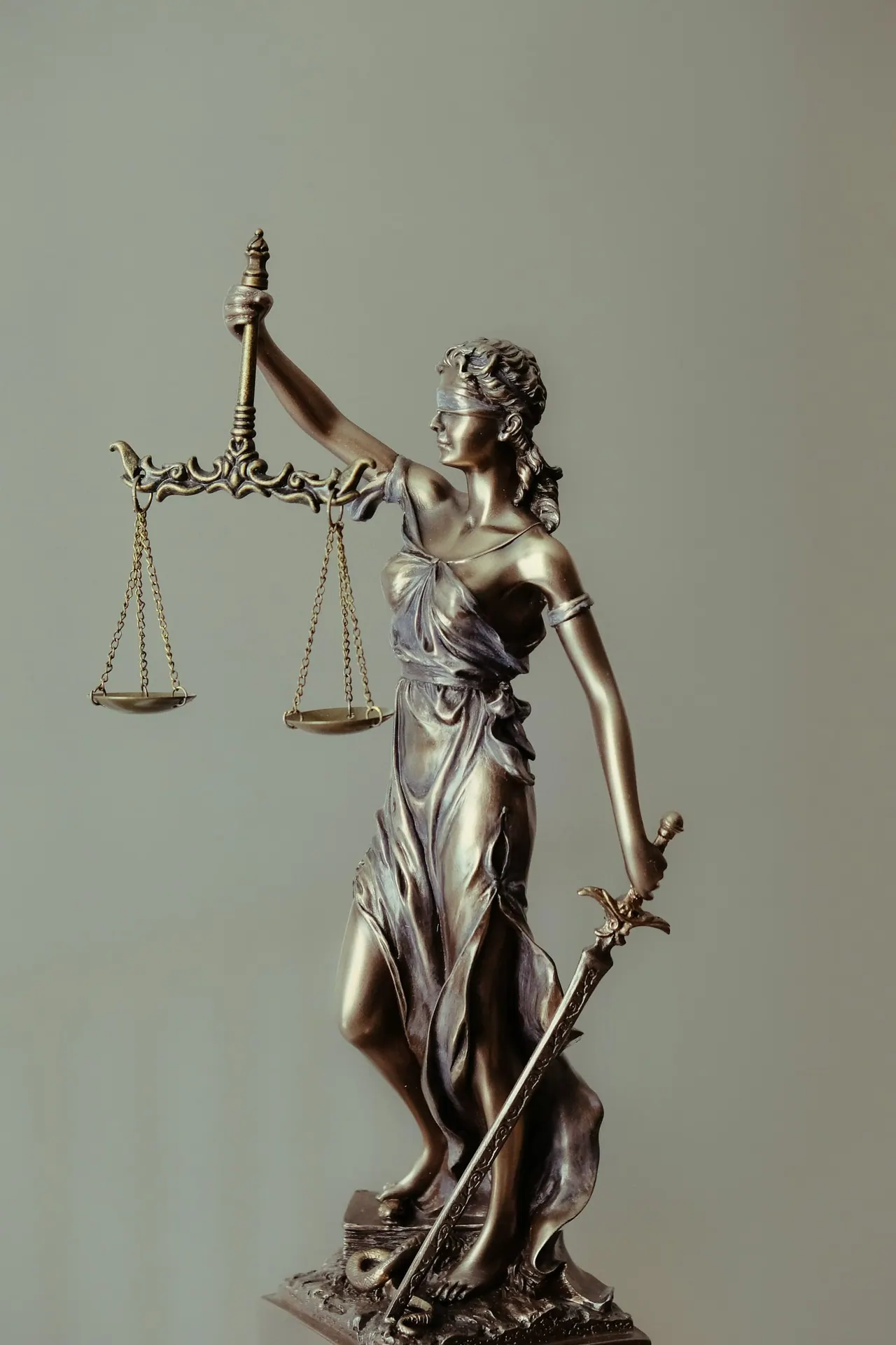 A bronze figurine of justice holding scales and a sword