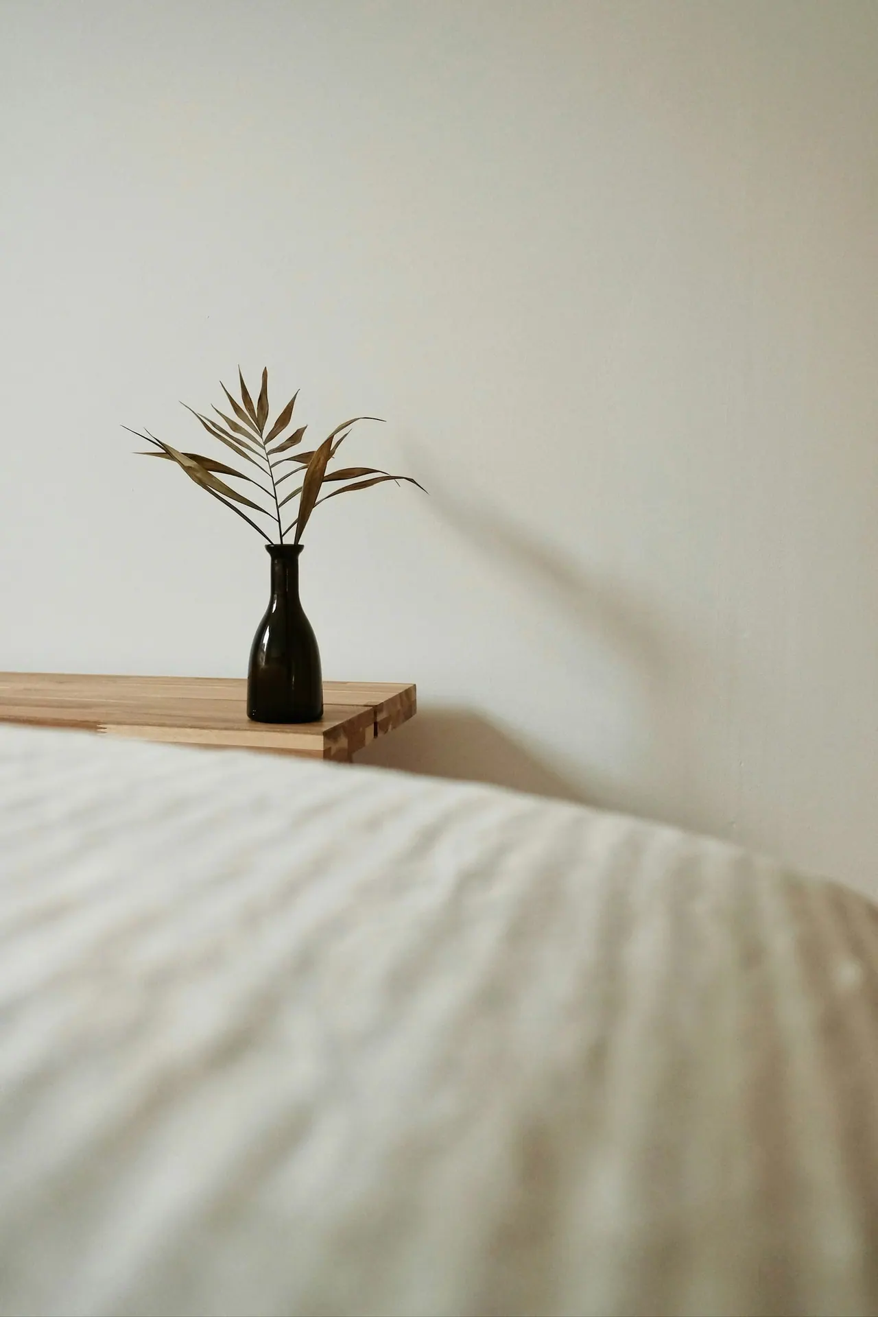 A vase with dried grasses beside a massage table