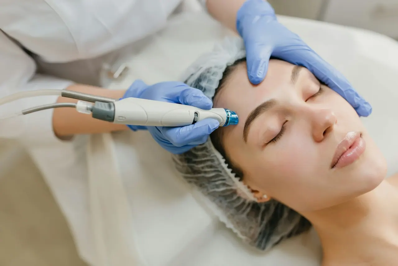 A skin therapist treating a client with a gentle facial device