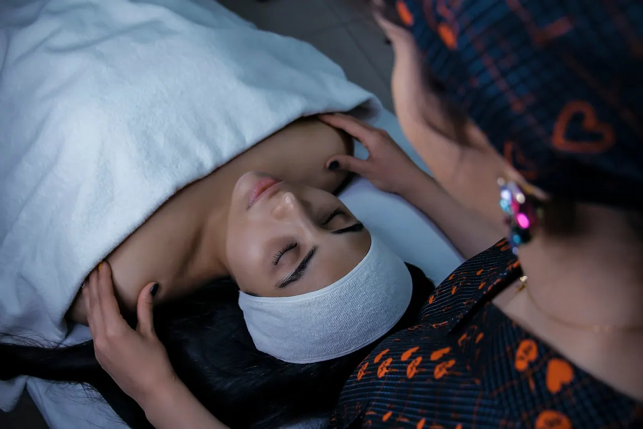 A therapist gently cradling a client's head during a calm facial