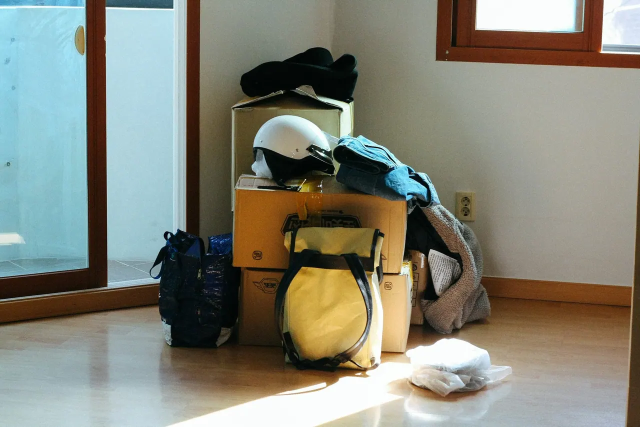 Packed bags and a helmet on boxes by a sunny window