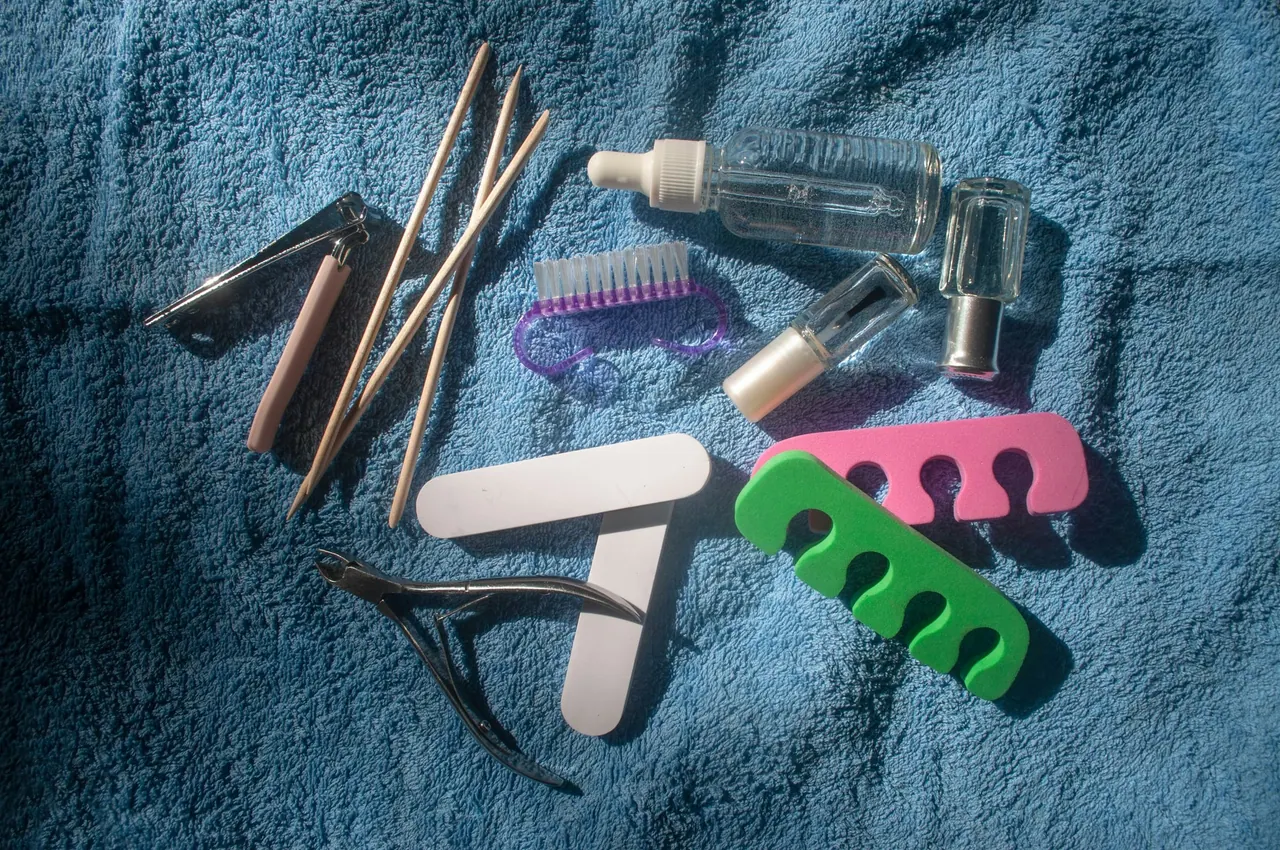 Clean manicure and pedicure tools laid out on a blue towel