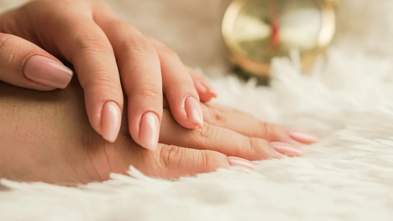 Hands with nude nails resting on white fur