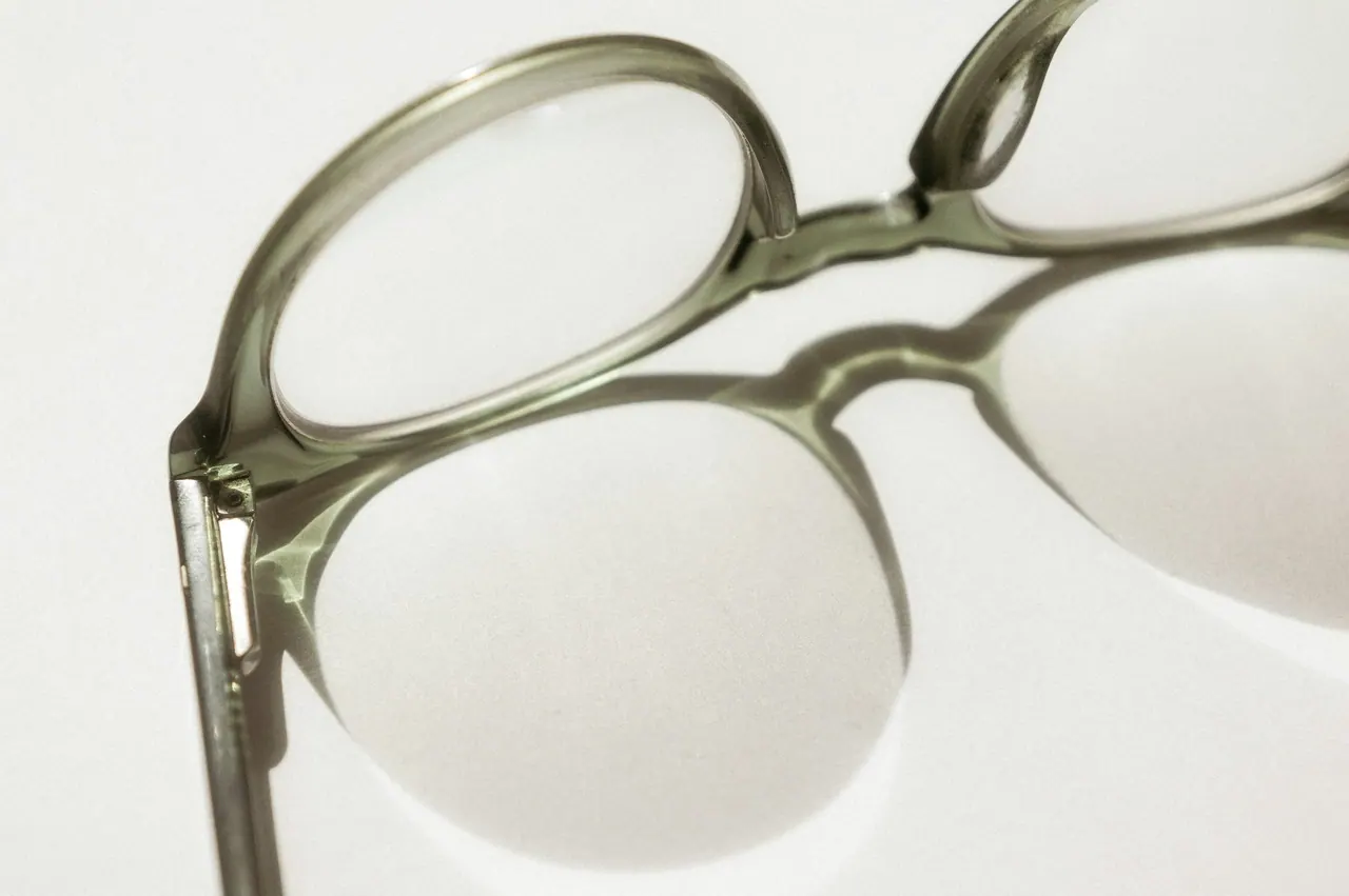 Grey translucent frames on a pale surface, casting a soft shadow
