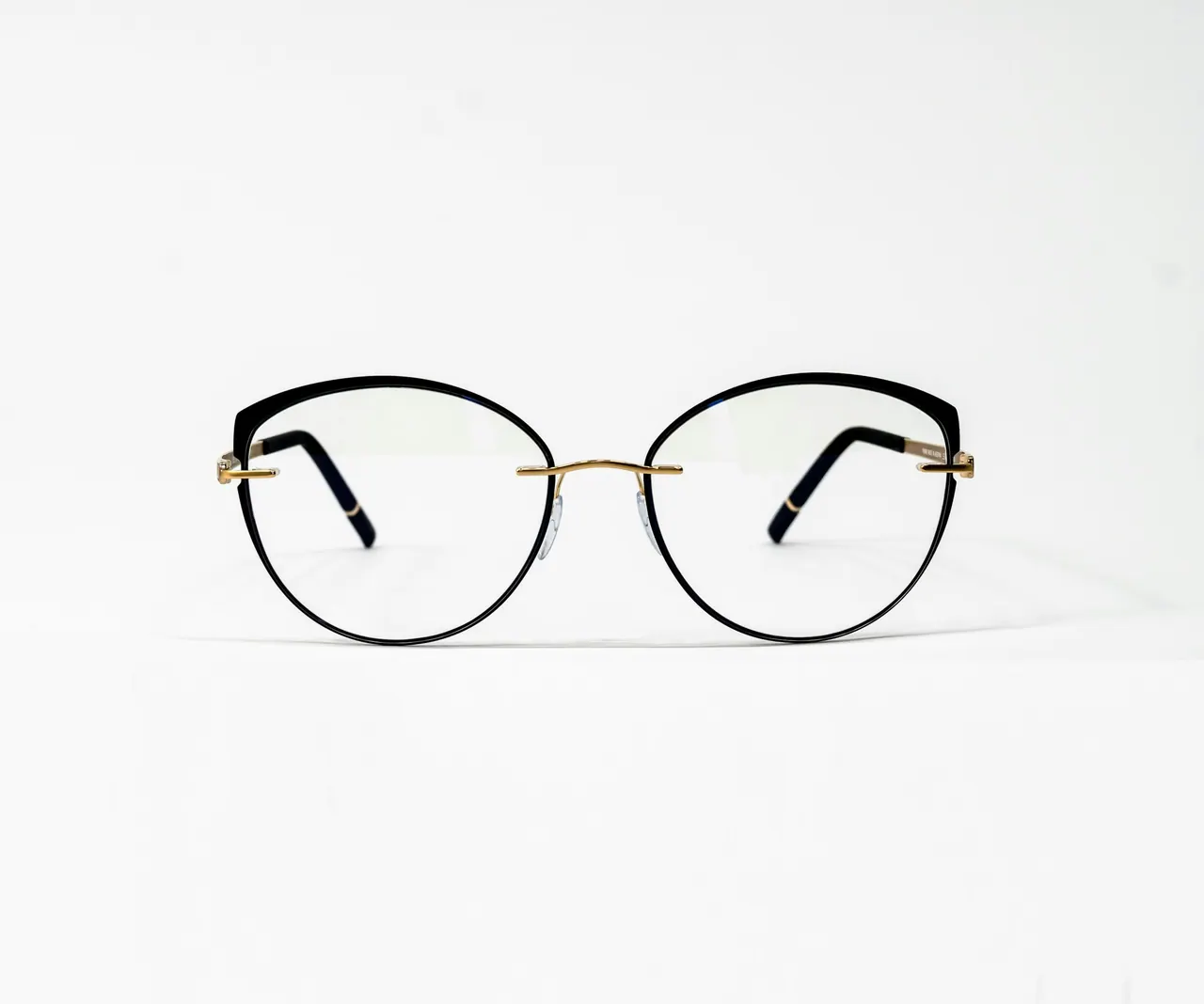 Fine round metal frames with gold temples on a white background
